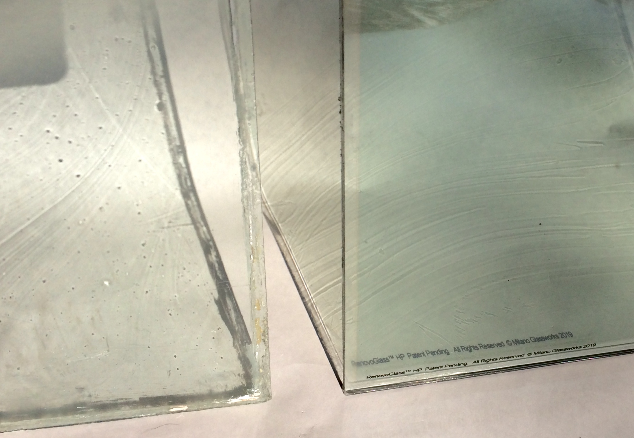 RenovoGlass™ HP (High Performance). This example illustrates a custom high performance restoration glass next to an original C1870 historic glass. Using natural light to project the subtle surface striation allows you to see exactly the nuance of our progressive historic glass products. The historic glass has many pits from over 140 years of exposure to the elements.