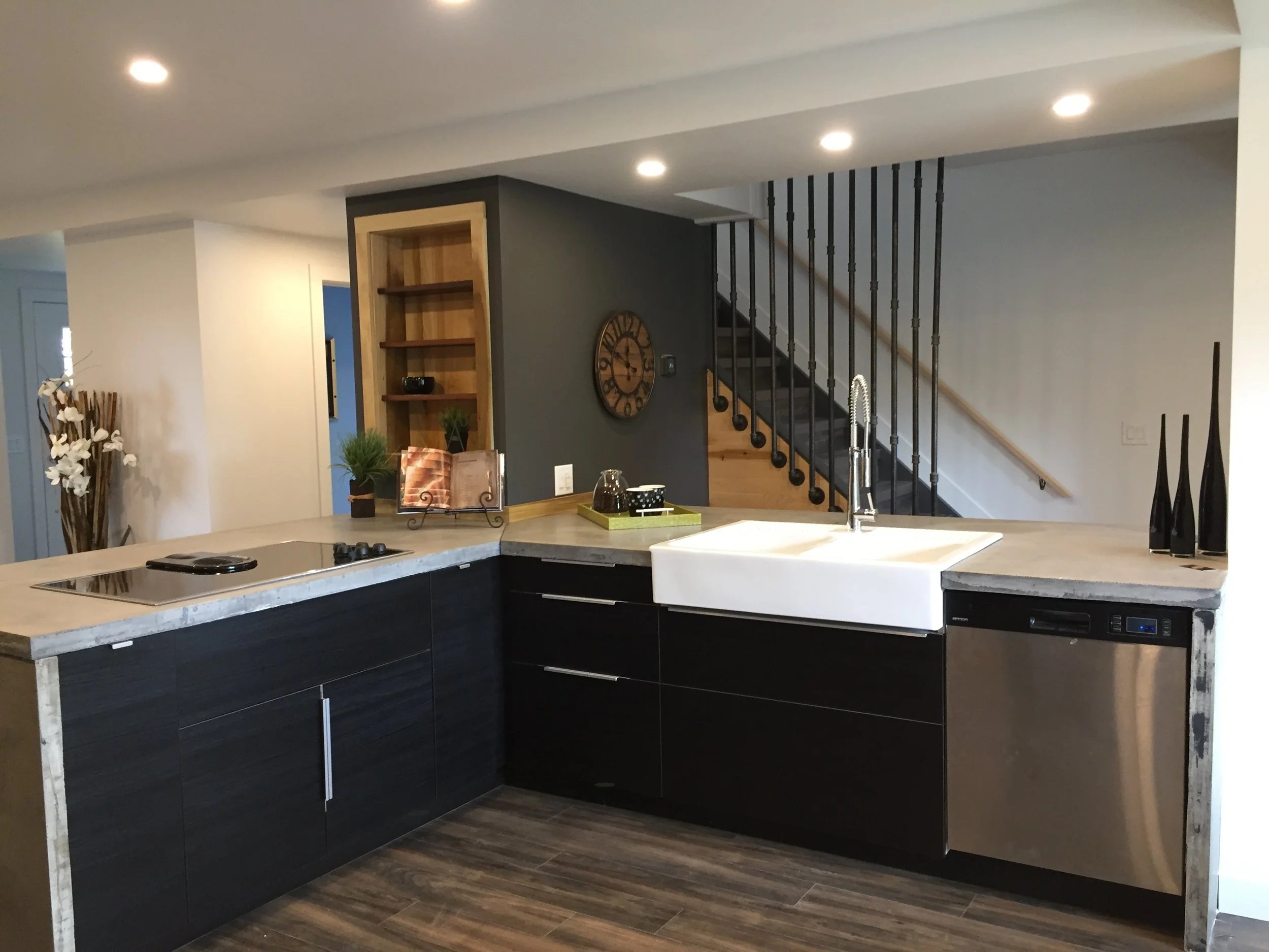 The Counters are Concrete, Farmhouse sink, Stainless taps and appliances, Pipe Wall Accents.