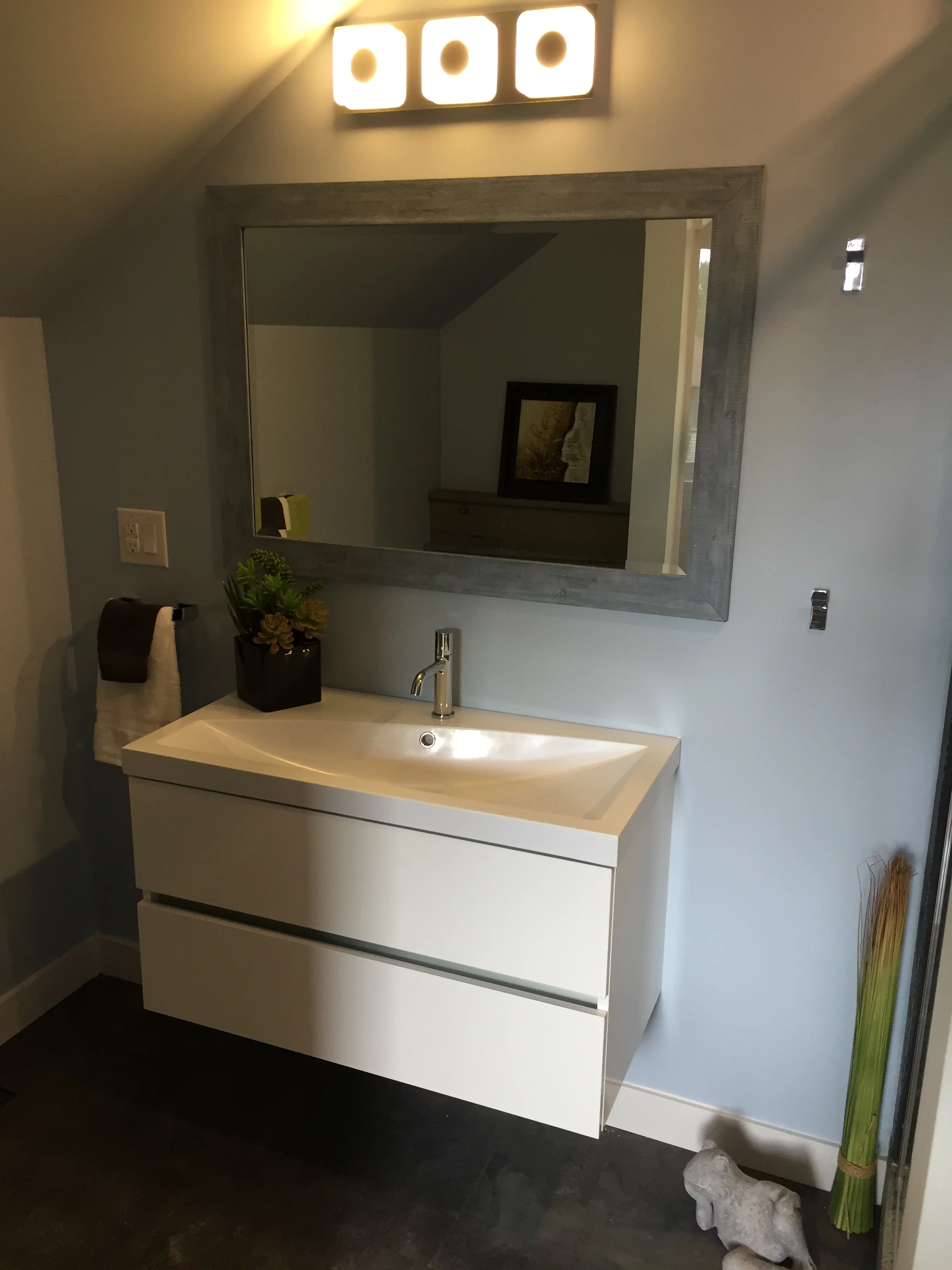 The Master Bath with everything tucked into spaces just right for their purpose. There is a concrete walled shower with Raintree showerhead to the right. A concrete frog is staged here just for fun!
