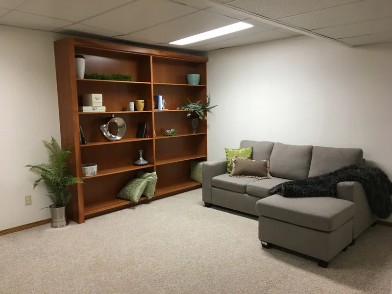This seemingly small room looks much bigger and more inviting with furnishings, and highlighting the built in bookcase.