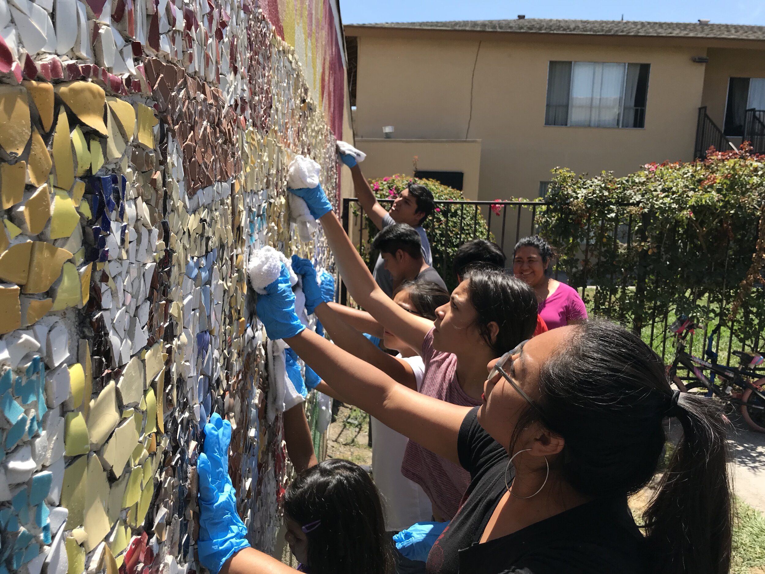 Alumni and students work together to restore the mural created by KidWorks students in 2007