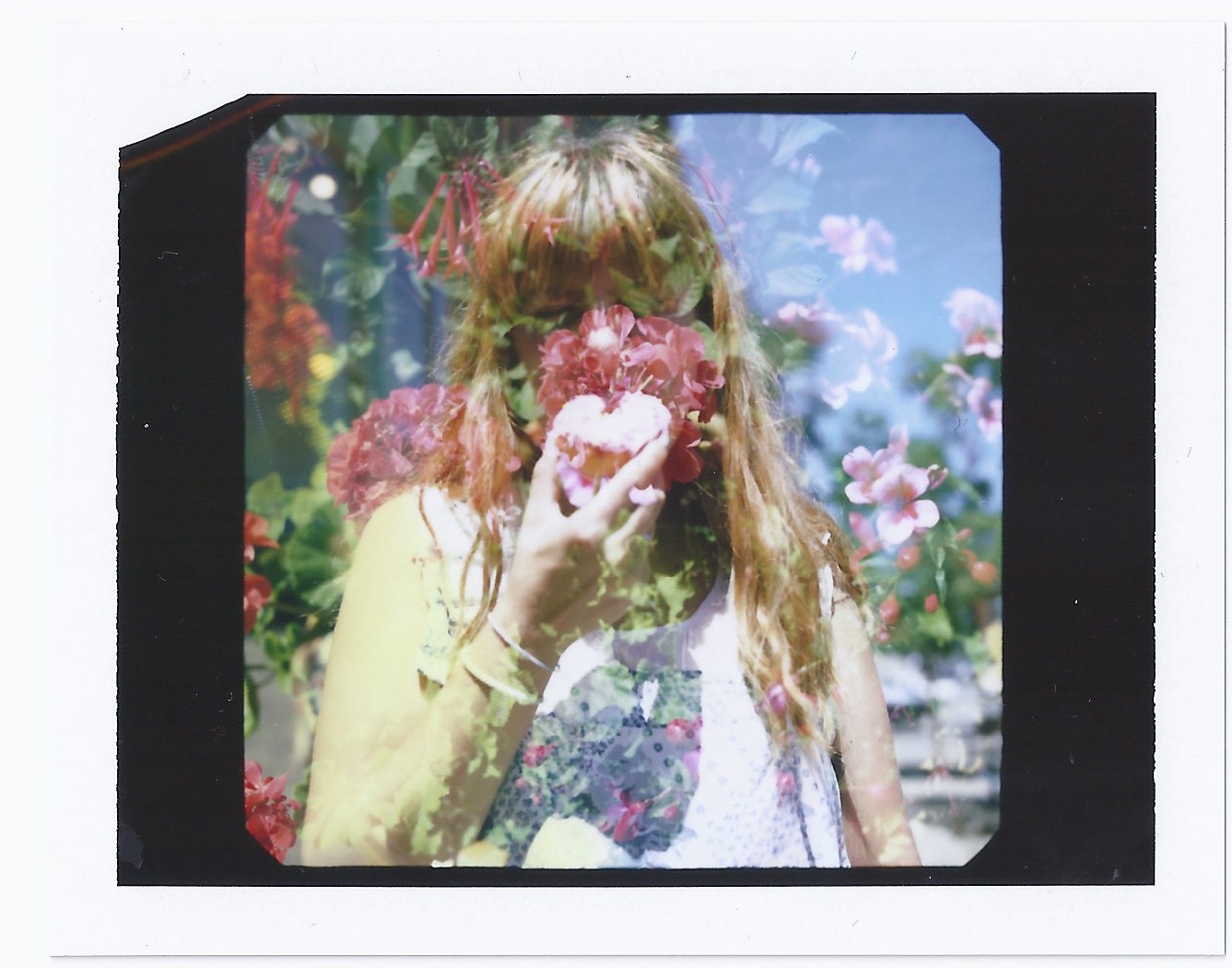 Young woman eats a donut with flowers in the background