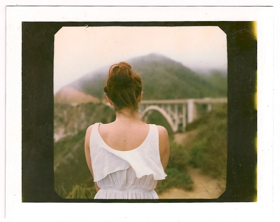 Girl stands with her back facing Bixby bridge, by Vancouver-based photographer Andrea Fernandez