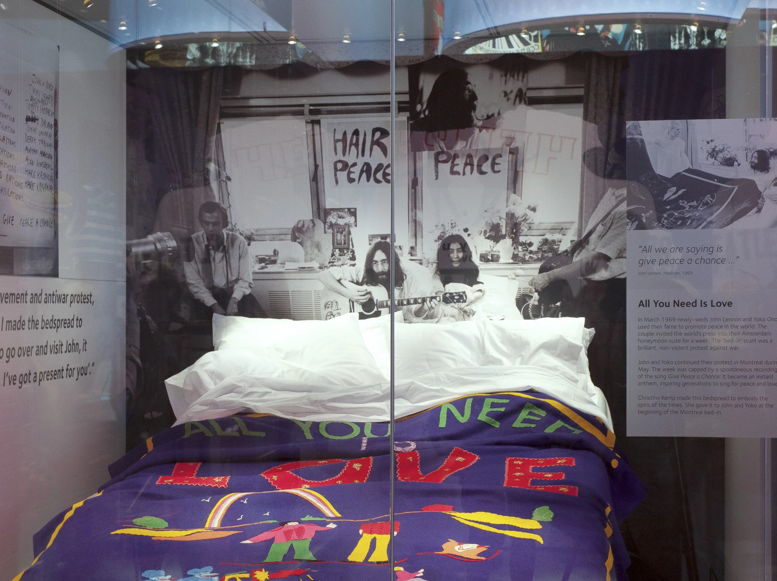 A glass display at the Museum of Liverpool containing John Lennon and Yoko Ono's 1969 peace protest bedspread, lit by Sutton Vane Associates.