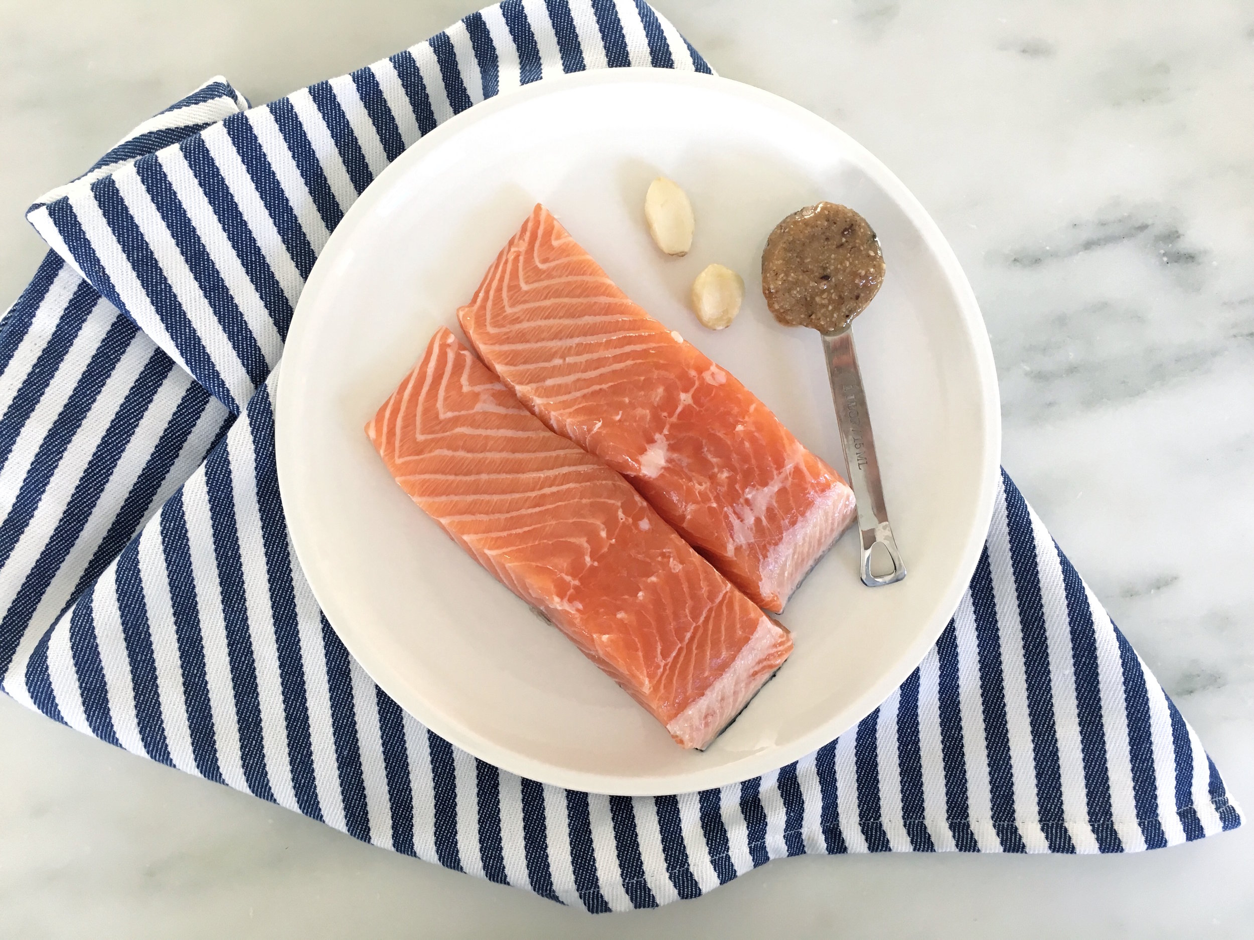 I used 2 cloves of garlic, hazelnut butter and oil, as suggested. The recipe gives crushed red pepper as an optional addition. After crushing the cloves and combining, I spread the mixture onto the filets. 