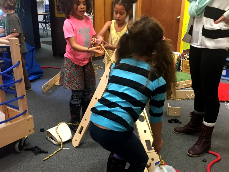 Students collaboratively pull jug up ramp