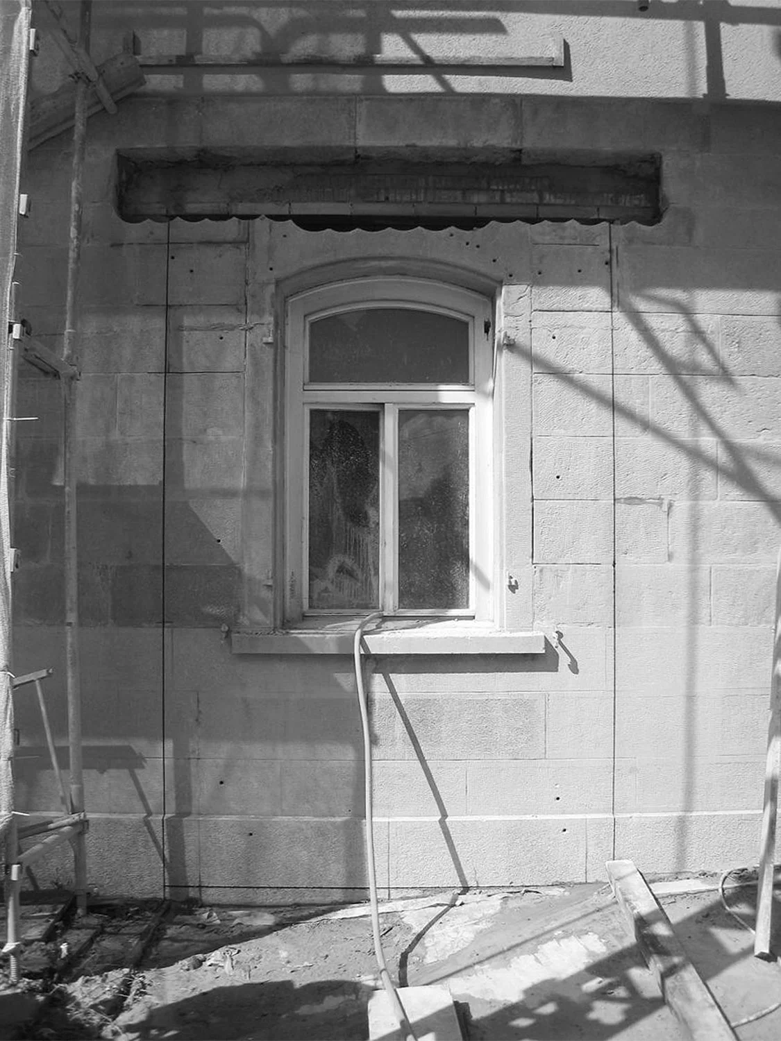Vorbereitete Vertikalschnitte in der bestehenden Fassade für den Mauerdurchbruch. 