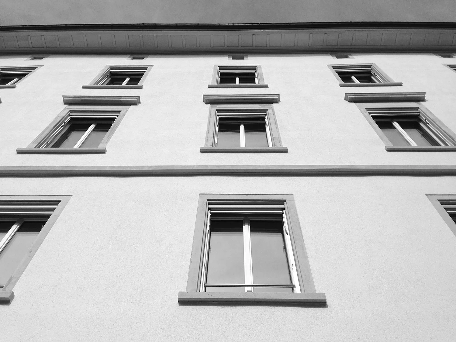 Die Fenstereinfassungen und Verdachungen wurden von Kunstharzfarbe befreit und lose, verwitterte Stellen mit Steinergänzungsmörtel reprofiliert.