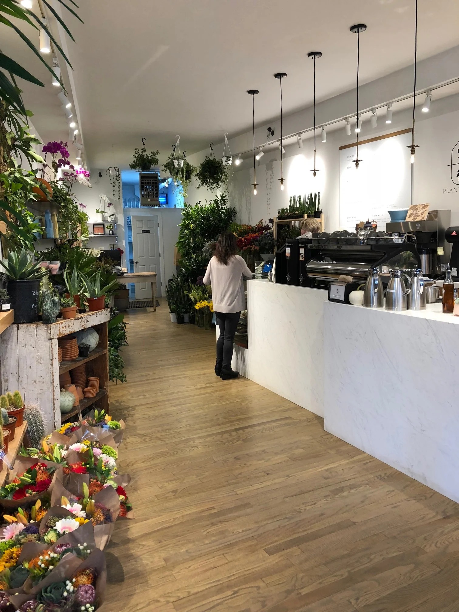 Coffee bar with waterfall front and so many plants and flowers.