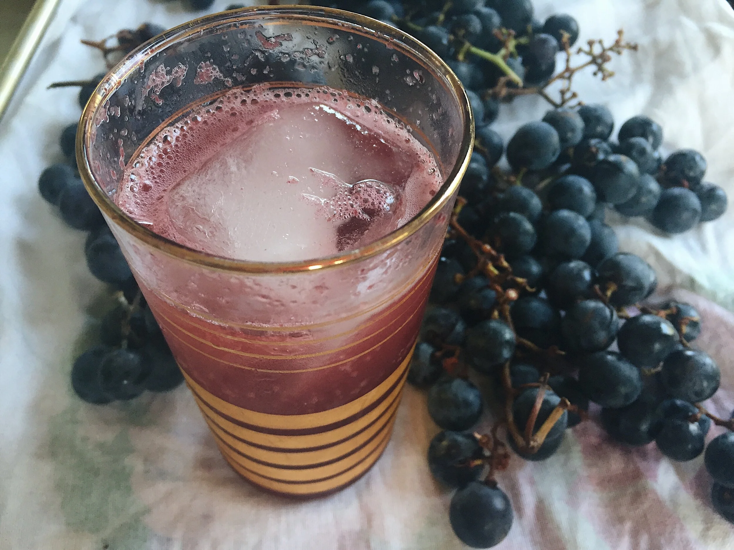 Concord grape shrub served with a little bubbly water. There’s a link to the recipe below!