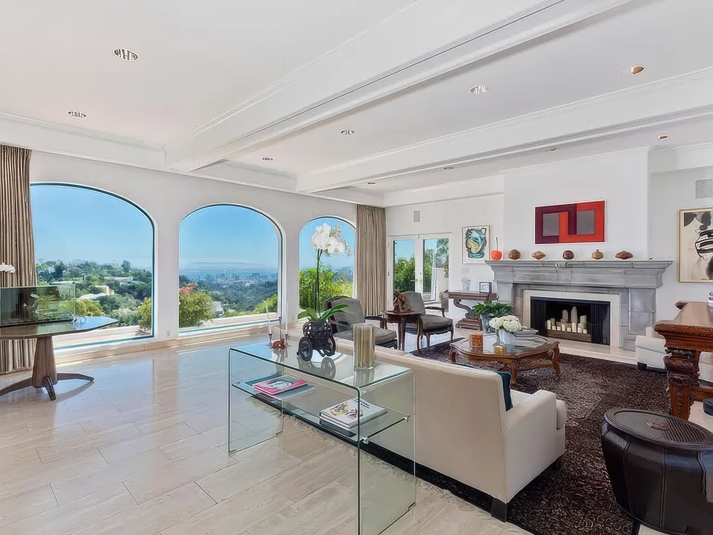 Living room with large arched windows, white walls, fireplace, and modern furniture.