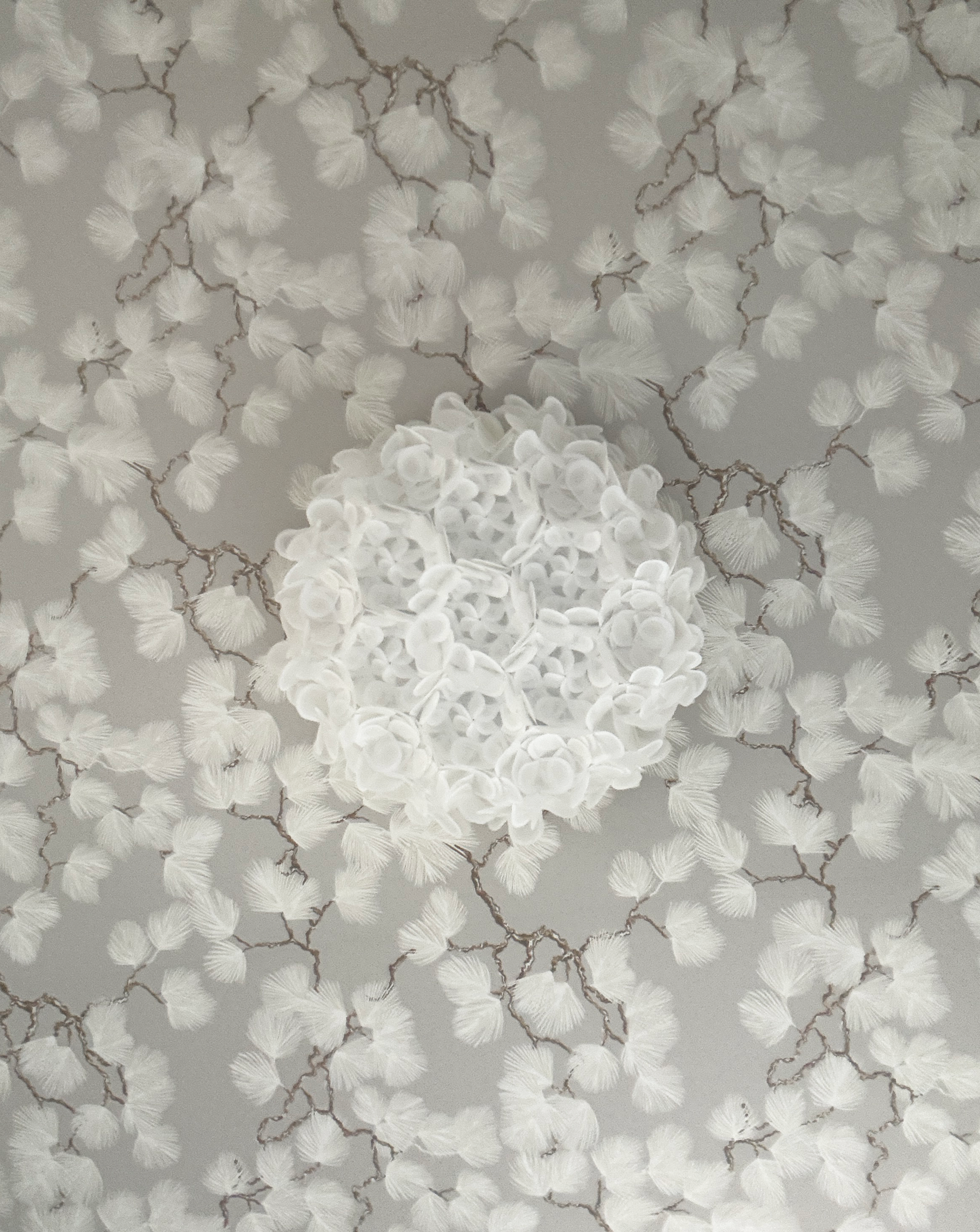A decorative ceiling light fixture with numerous white fan-shaped glass shades arranged in a circular pattern, connected by a network of brown metal branches.