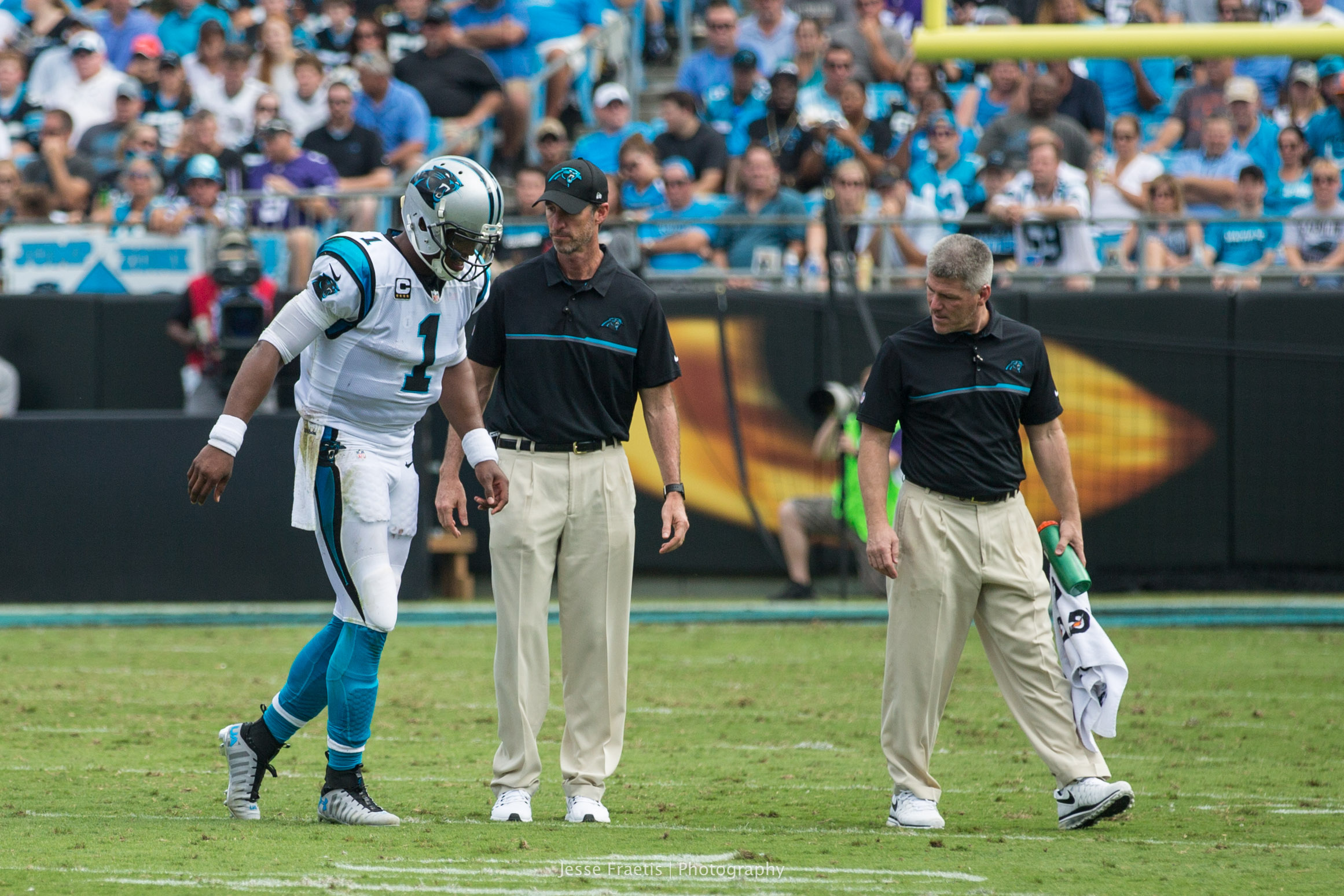 A limping Cam assisted off the field by doctors.