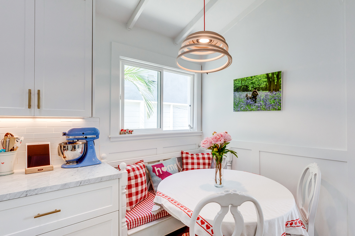 A breakfast nook at the corner of the kitchen and foyer. Perfect detail for this kitchen and adorably decorated.