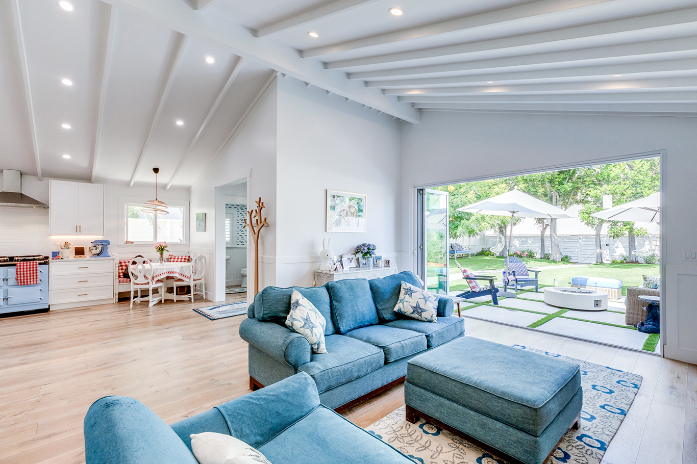 The ceiling is now vaulted with exposed beams which adds depth to the design while simultaneously expanding the room. The outdoor elements are incorporated into the living room with the wide open pocket door.