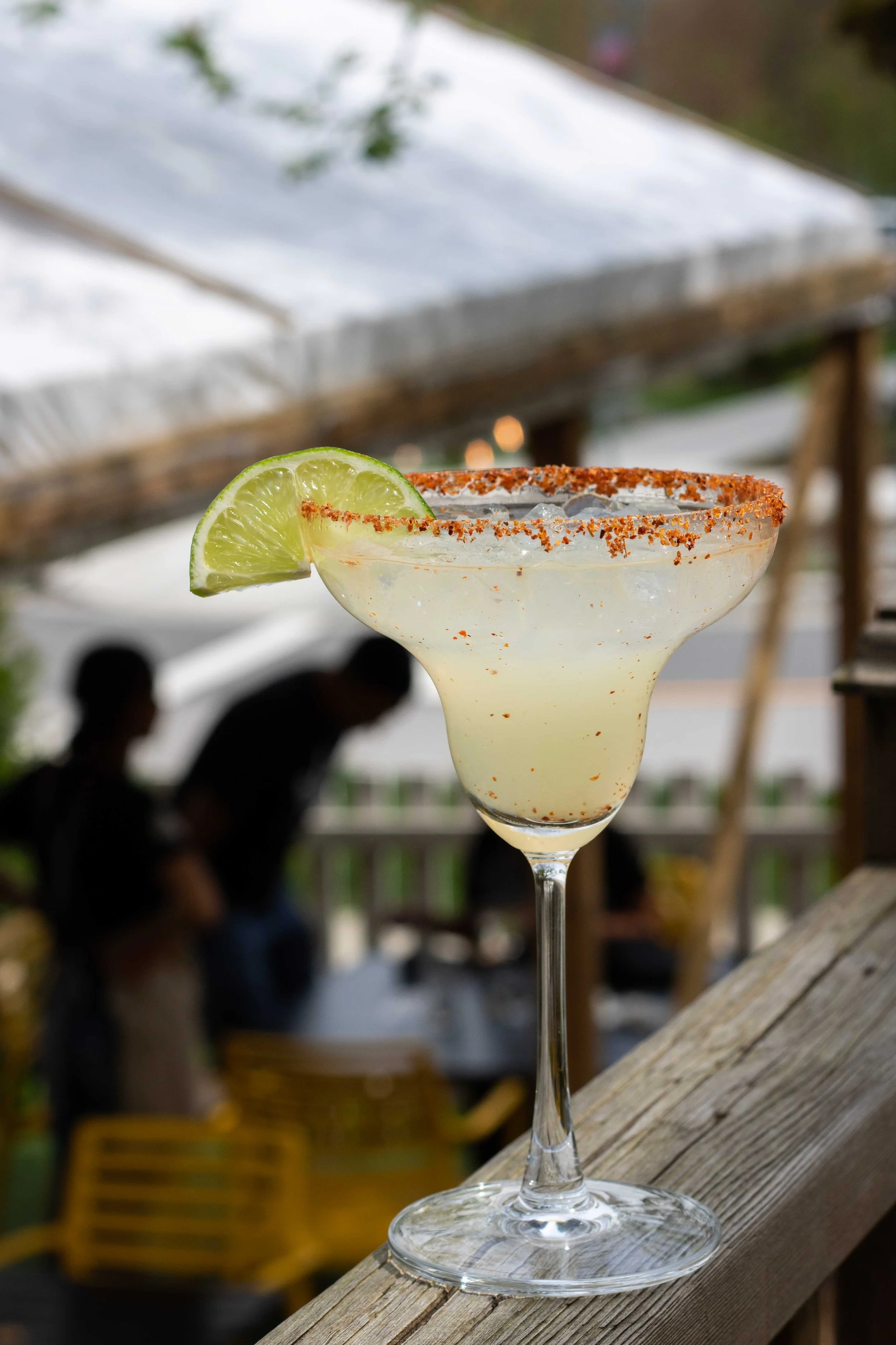 Margarita with a chili-salt rim and a lime wedge on the patio rail at Original’s