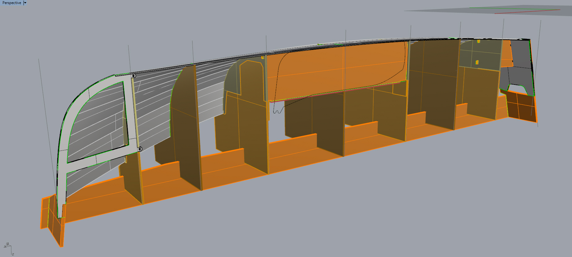 The building jig set up of the 18 uses particleboard (orange) for the strongback and molds. Bulkheads, frames, and centerboard mount as part of the set-up, as does the stem and transom. When the boat is flipped, only seating and tank tops need to be installed.