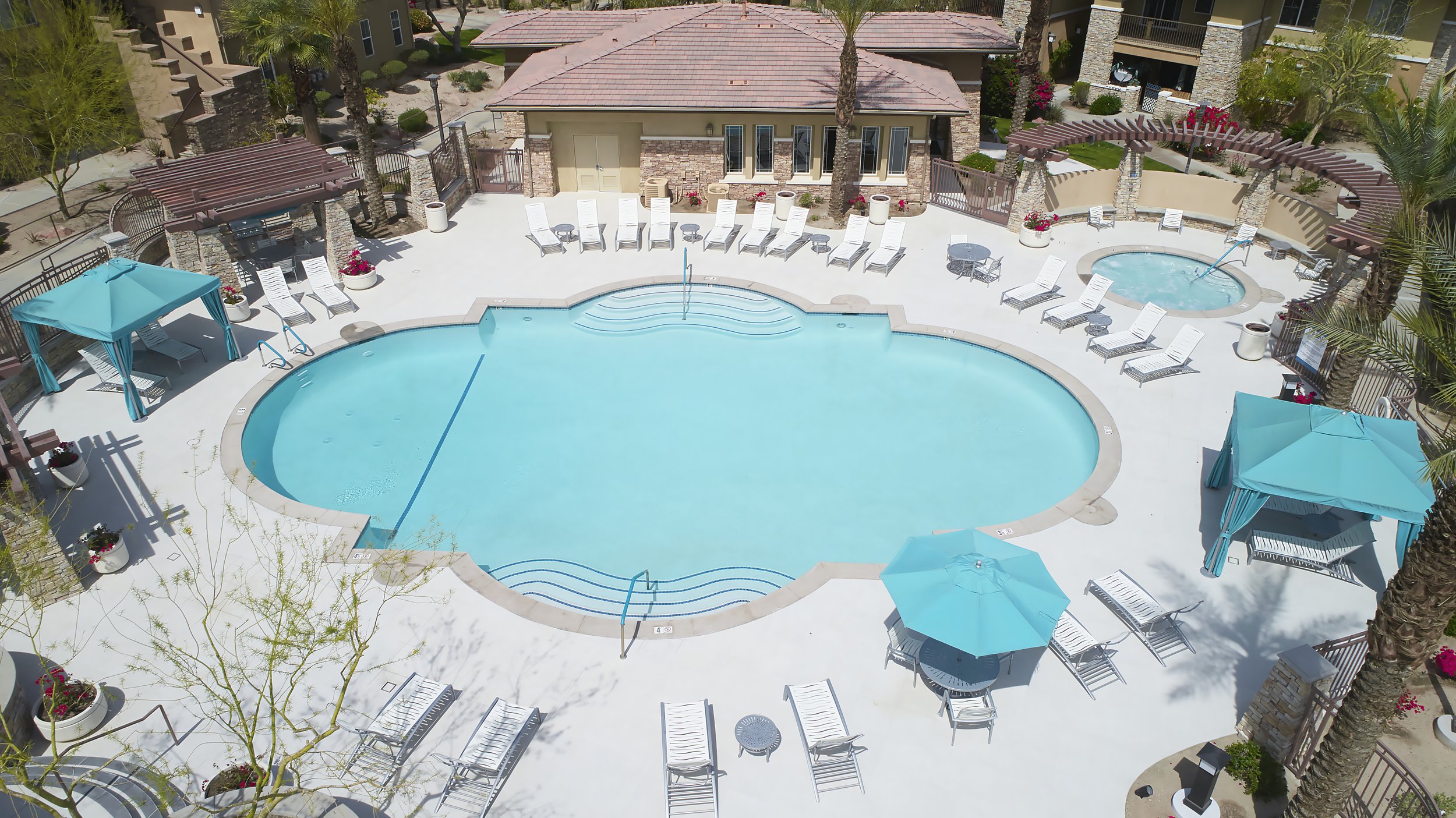  Our beautiful blue pool and jacuzzi, surrounded by lots of seating and cabanas. 