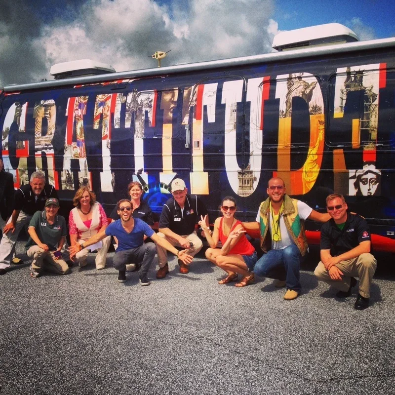 Group sitting in front of the Gratitude Bus.