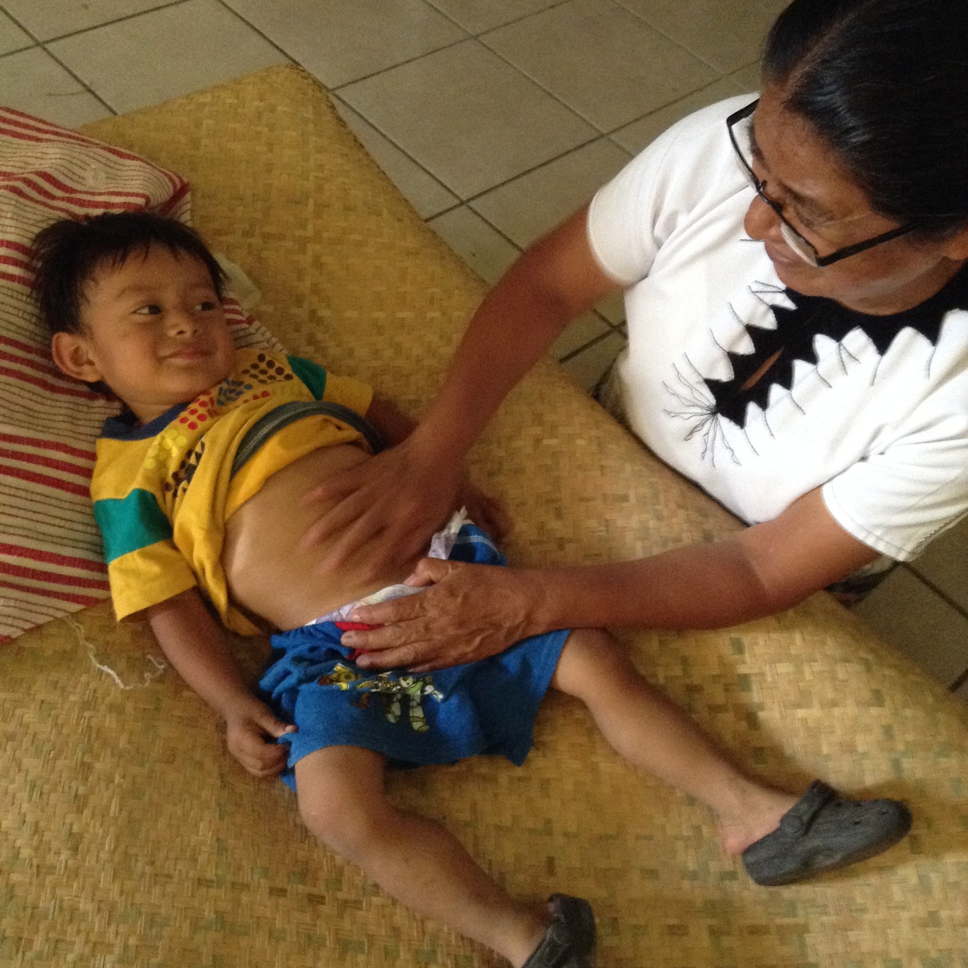 Hermana Marucca give a stomach massage to patient in the Basurera - Guatemala City