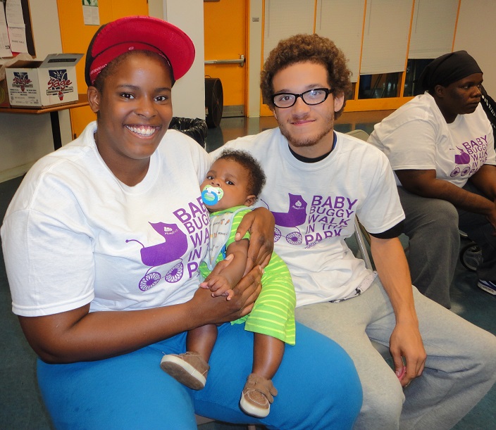 A MomsFirst family proudly displaying their Baby Buggy Walk t-shirts.