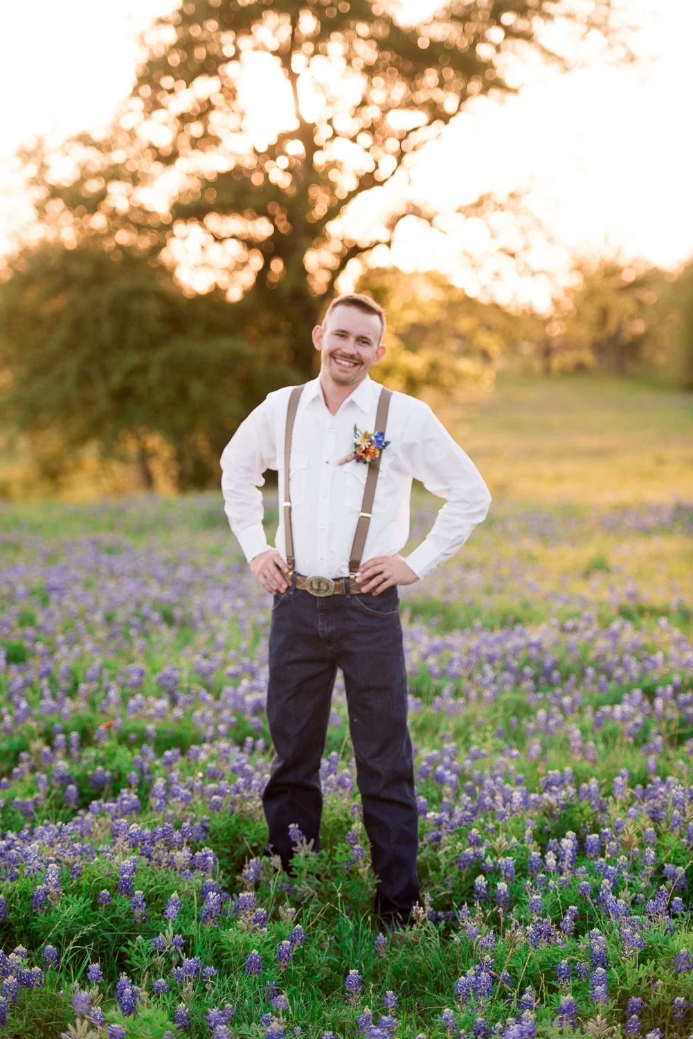 89 groom photos in field of bluebonnets with suspenders.jpg