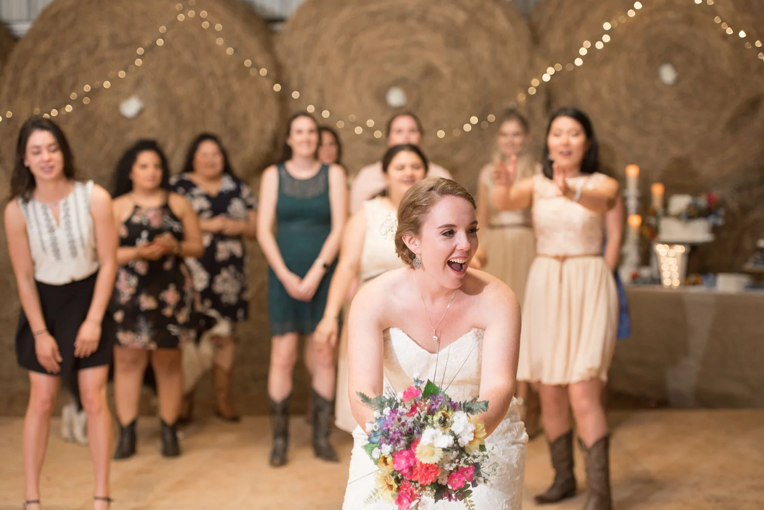 121 bride tosses bouquet to girls in barn wedding.jpg