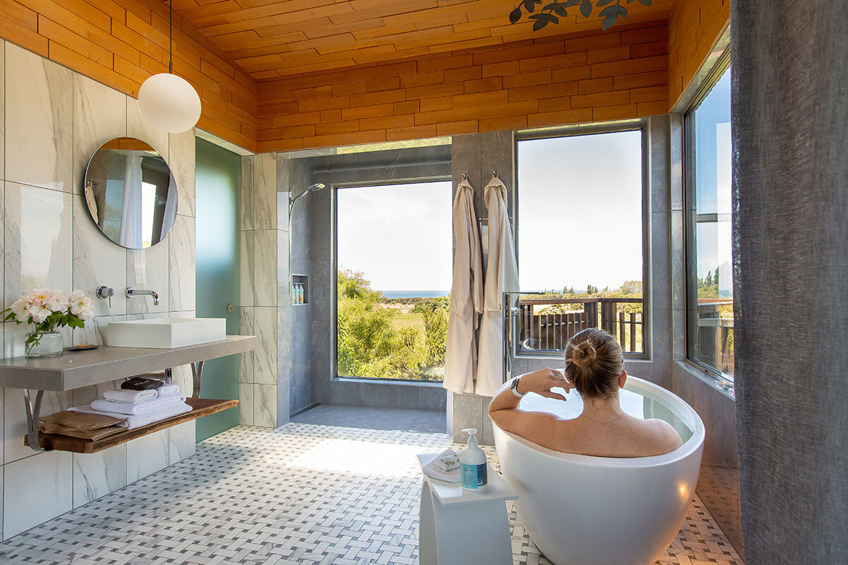 The upper branch bedroom has a tub and ocean view shower.