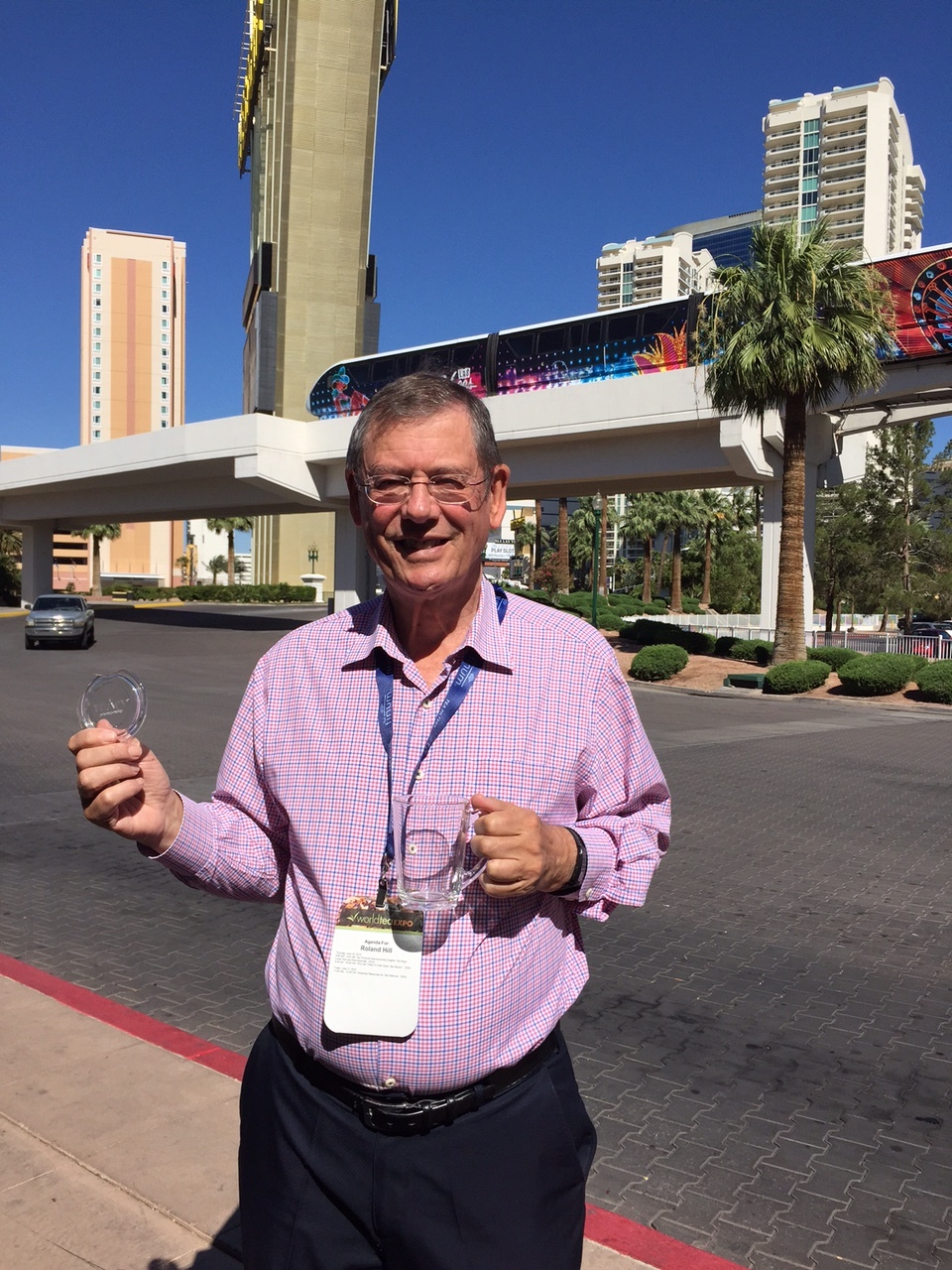 Roland Hill with TEAPY® at the World Tea Expo in Las Vegas. His Contra Vision one-way vision invention is shown on the windows of the monorail in the background.