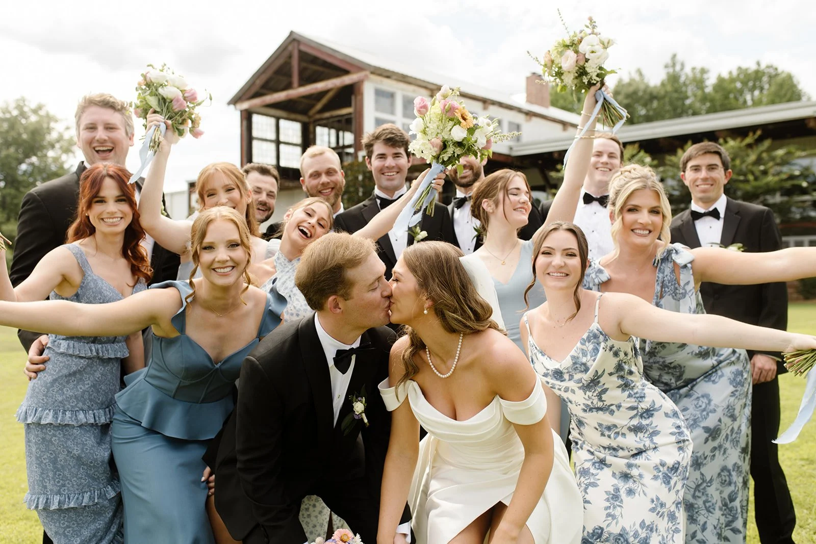 couple with bridal party kissing after wedding at jefferson oxford MS