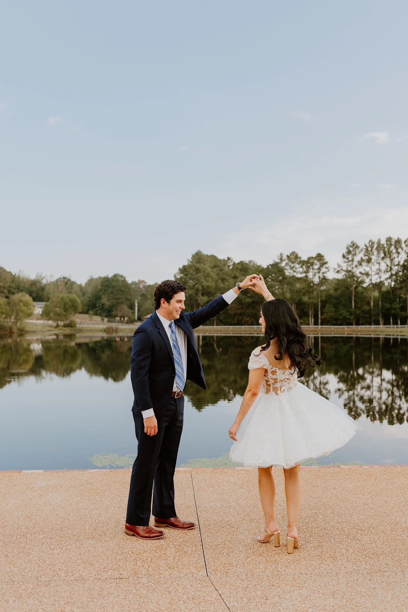 couple twirling along lakefront walkway at wedding dinner at The Jefferson Oxford