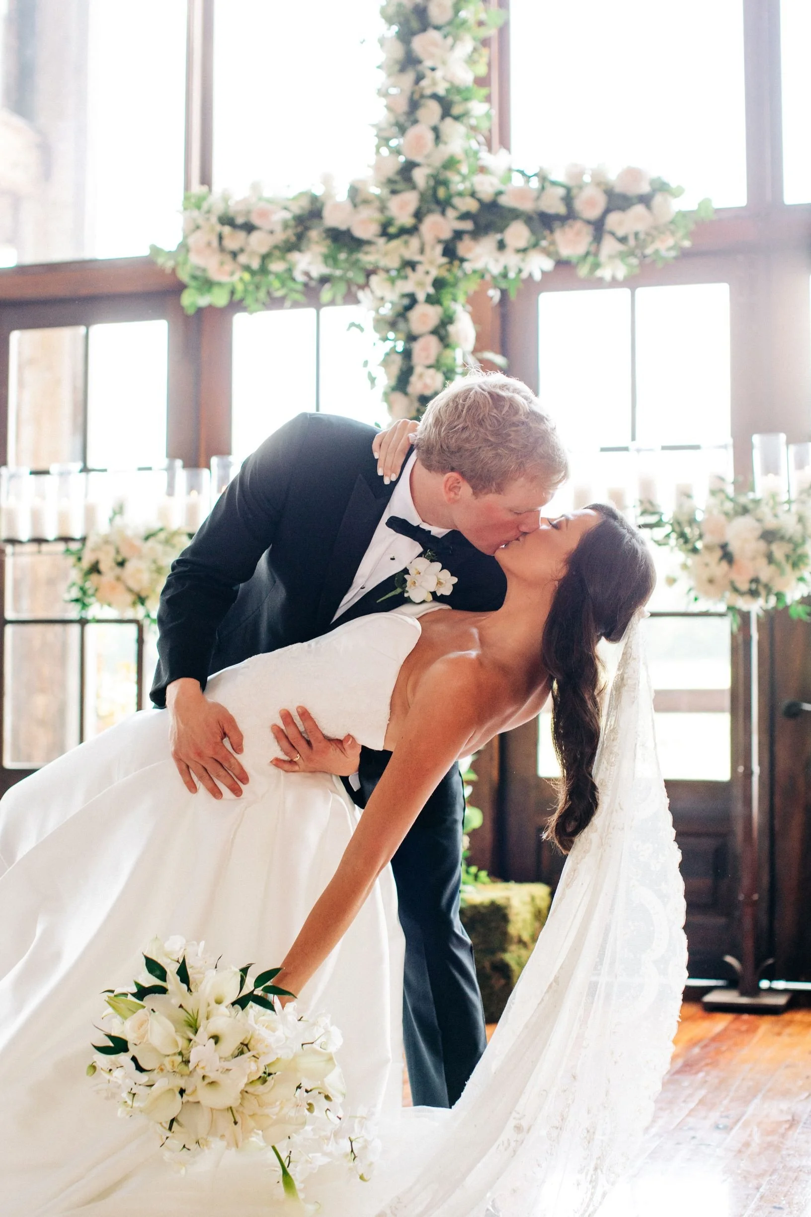 couple kissing in front of a floral cross at the jefferson oxford