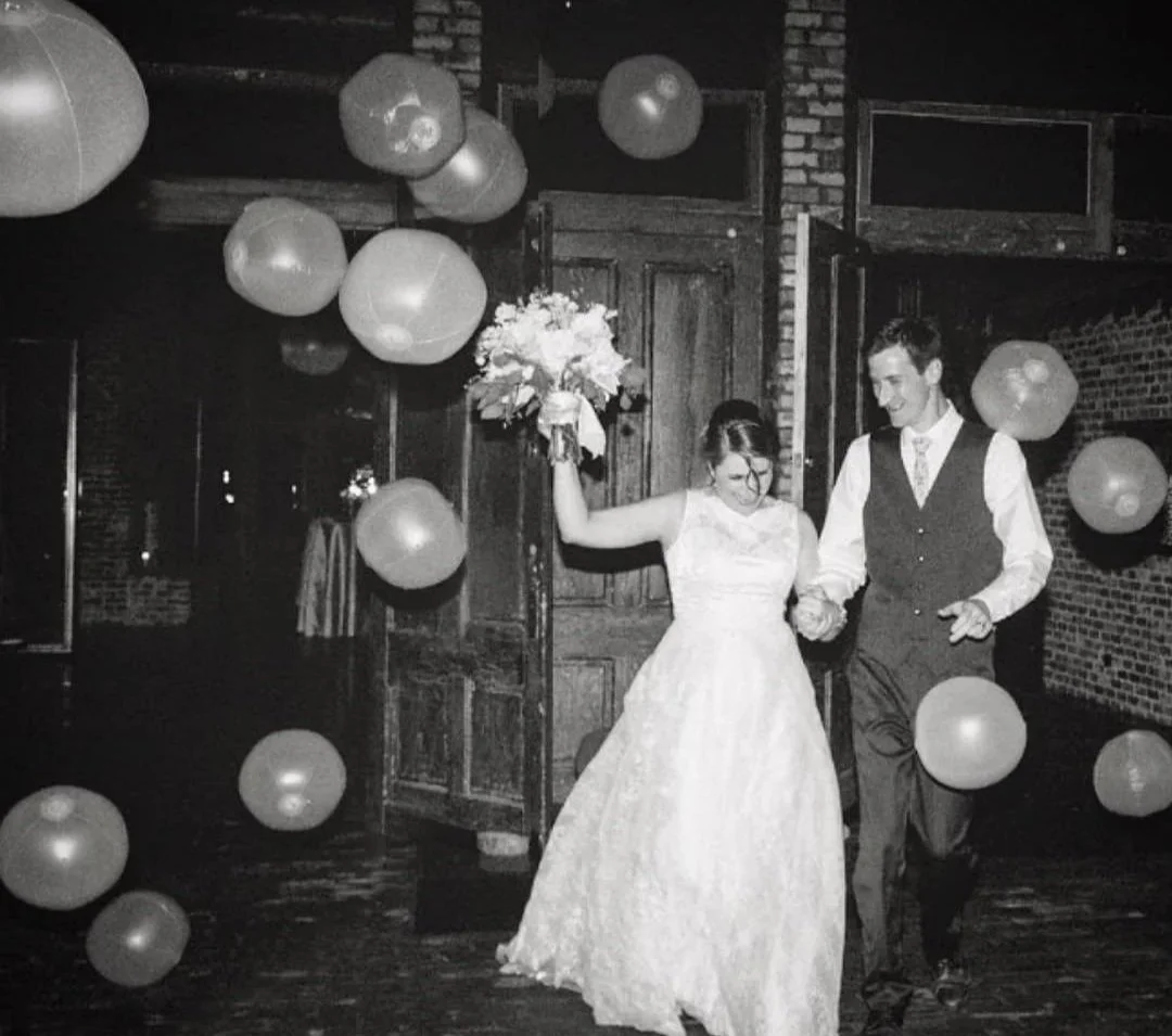 guests toss balloons at couple as they depart wedding reception at Jefferson Oxford