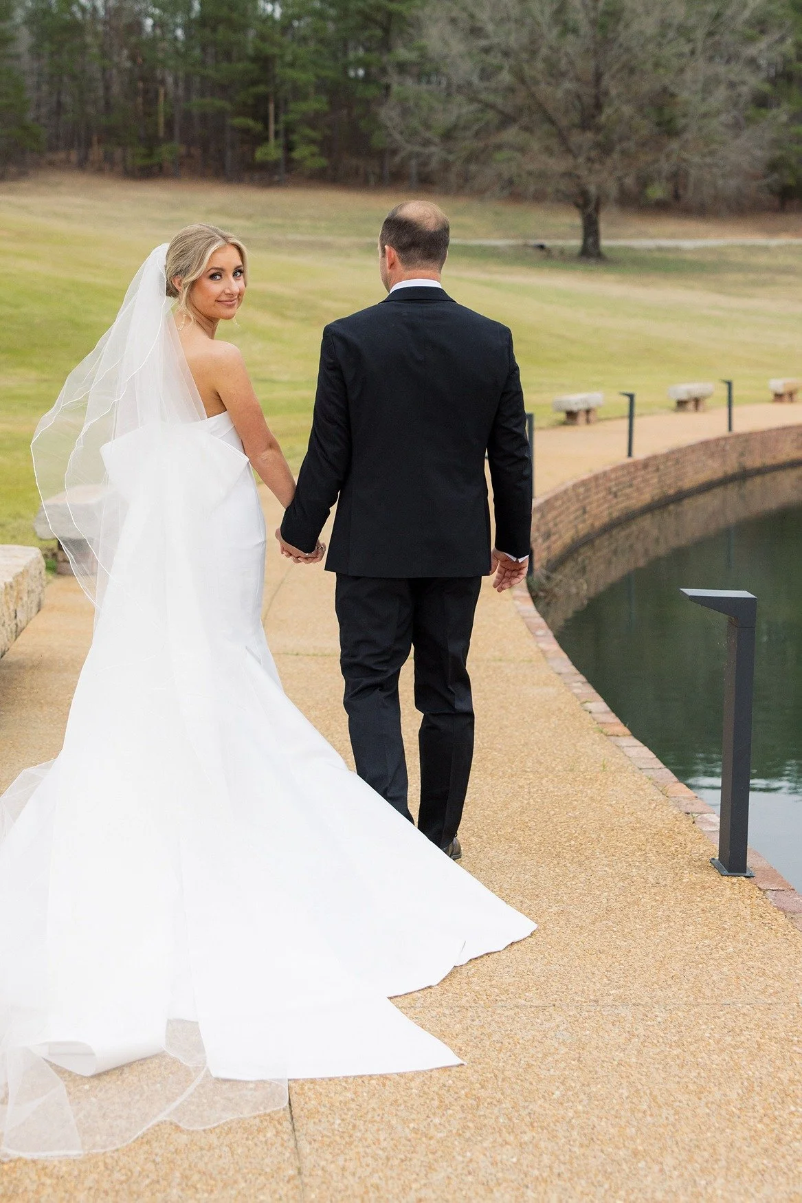 bride looking over shoulder lakefront walkway Jefferson Oxford MS