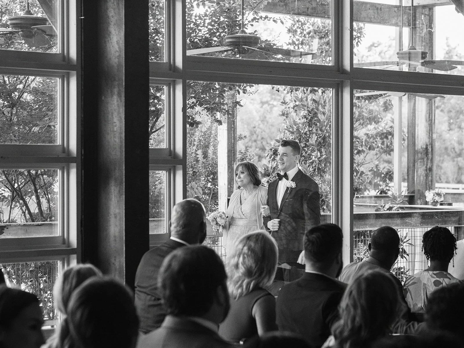 groom ushers family into ceremony in lakeside room at The Jefferson Oxford