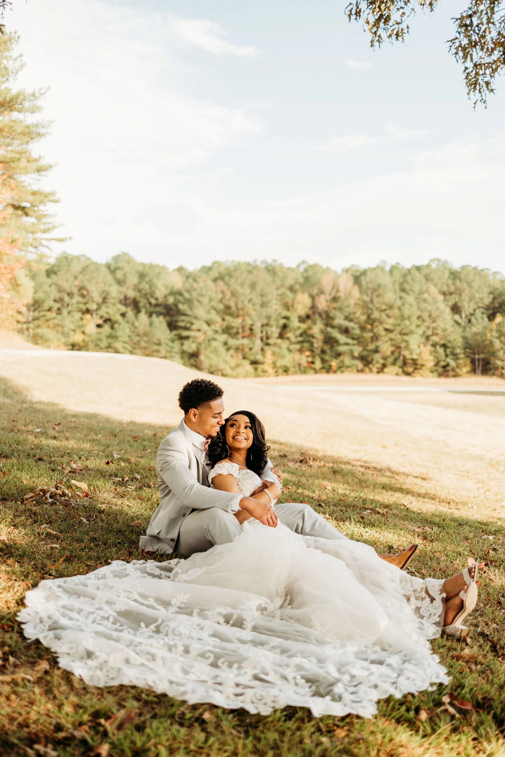 couple sitting on the grass under large tree at the jefferson oxford MS