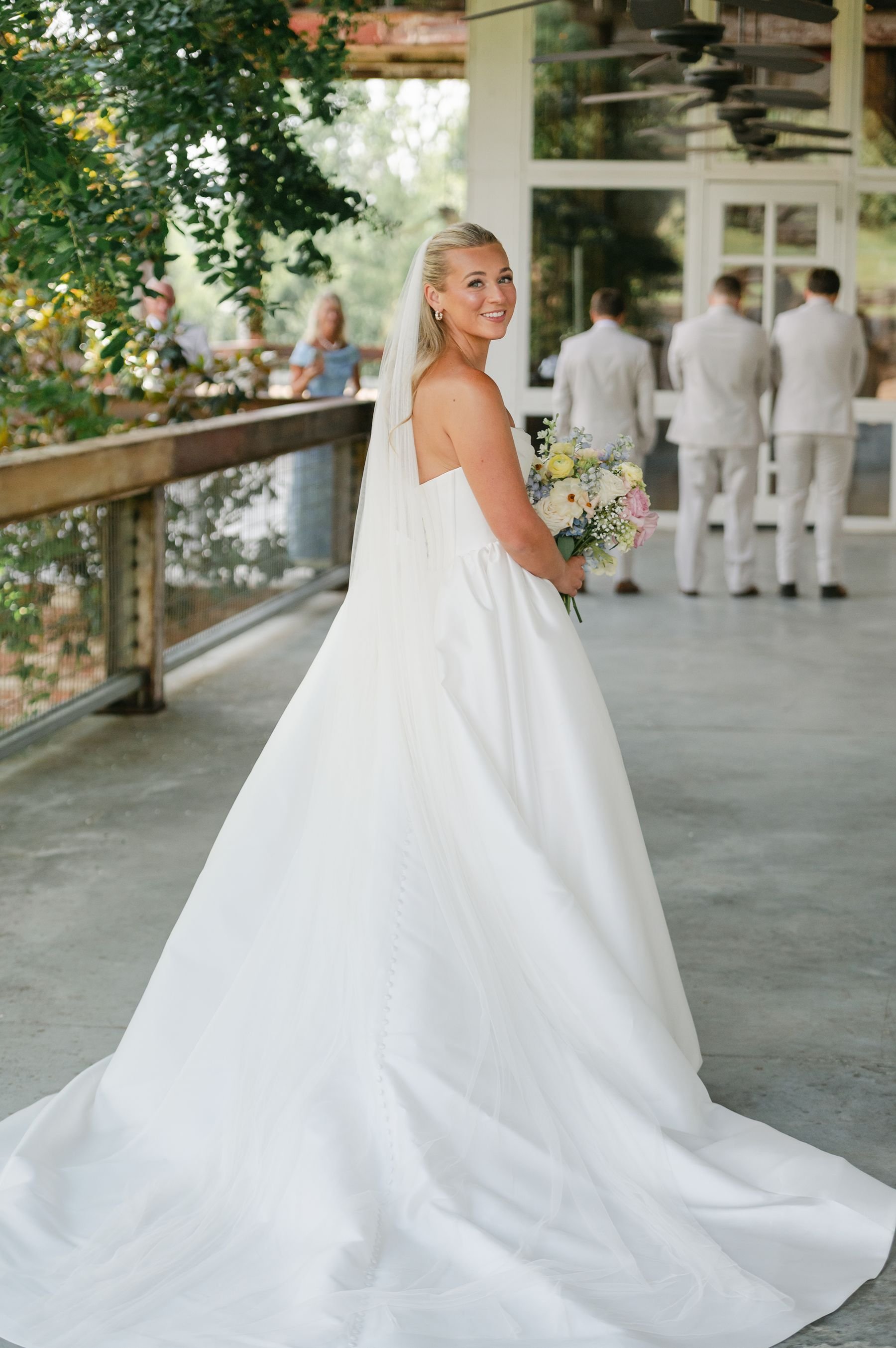 first look bride with groomsmen on covered porch at The Jefferson Oxford