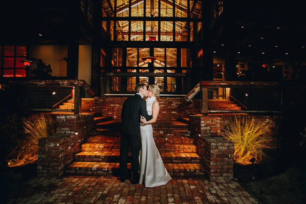 couple kissing outside during reception on the lakefront stairwell jefferson oxford ms