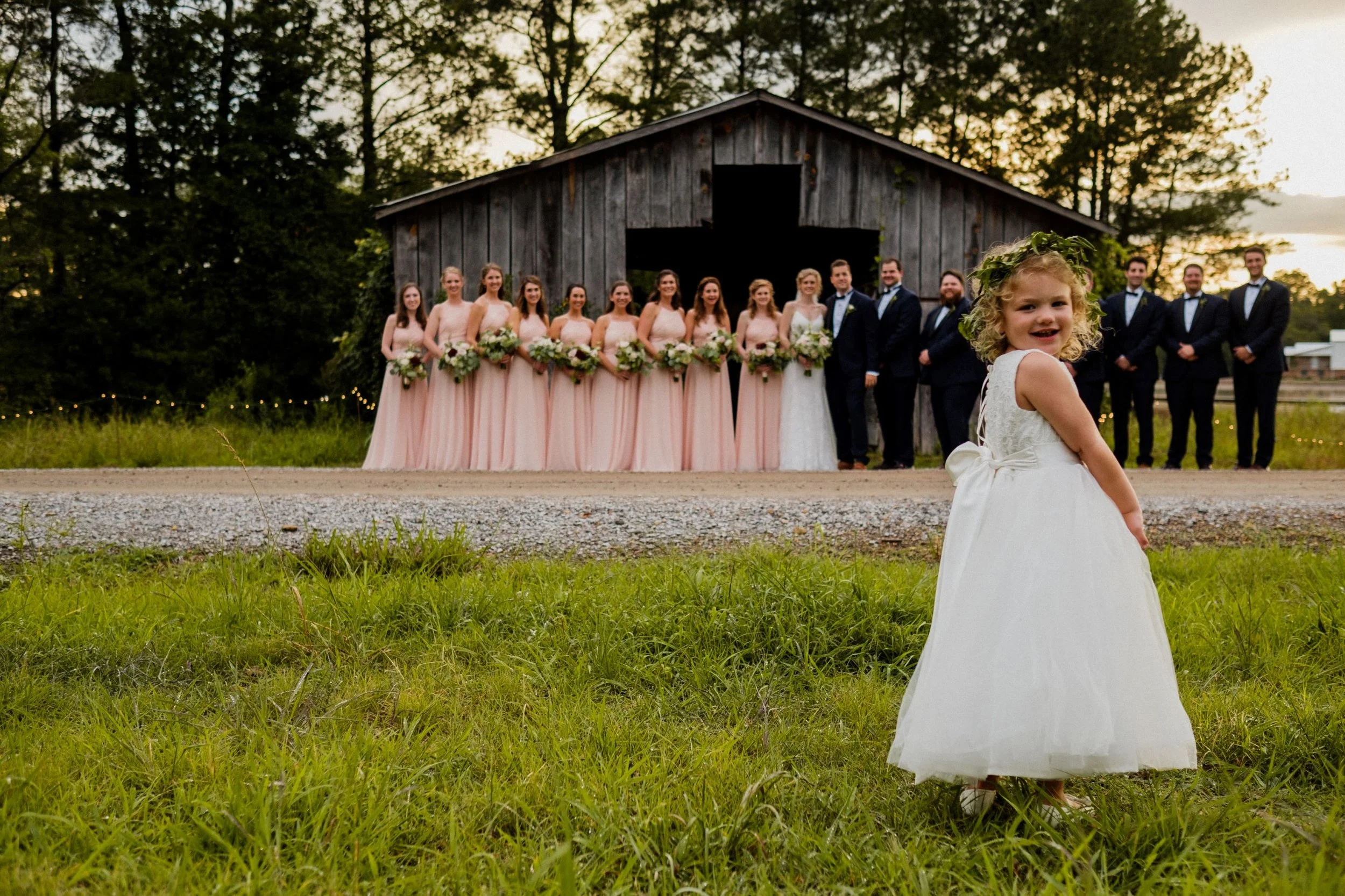 bridal party with flower girl in front of barn on wedding day at jefferson oxford