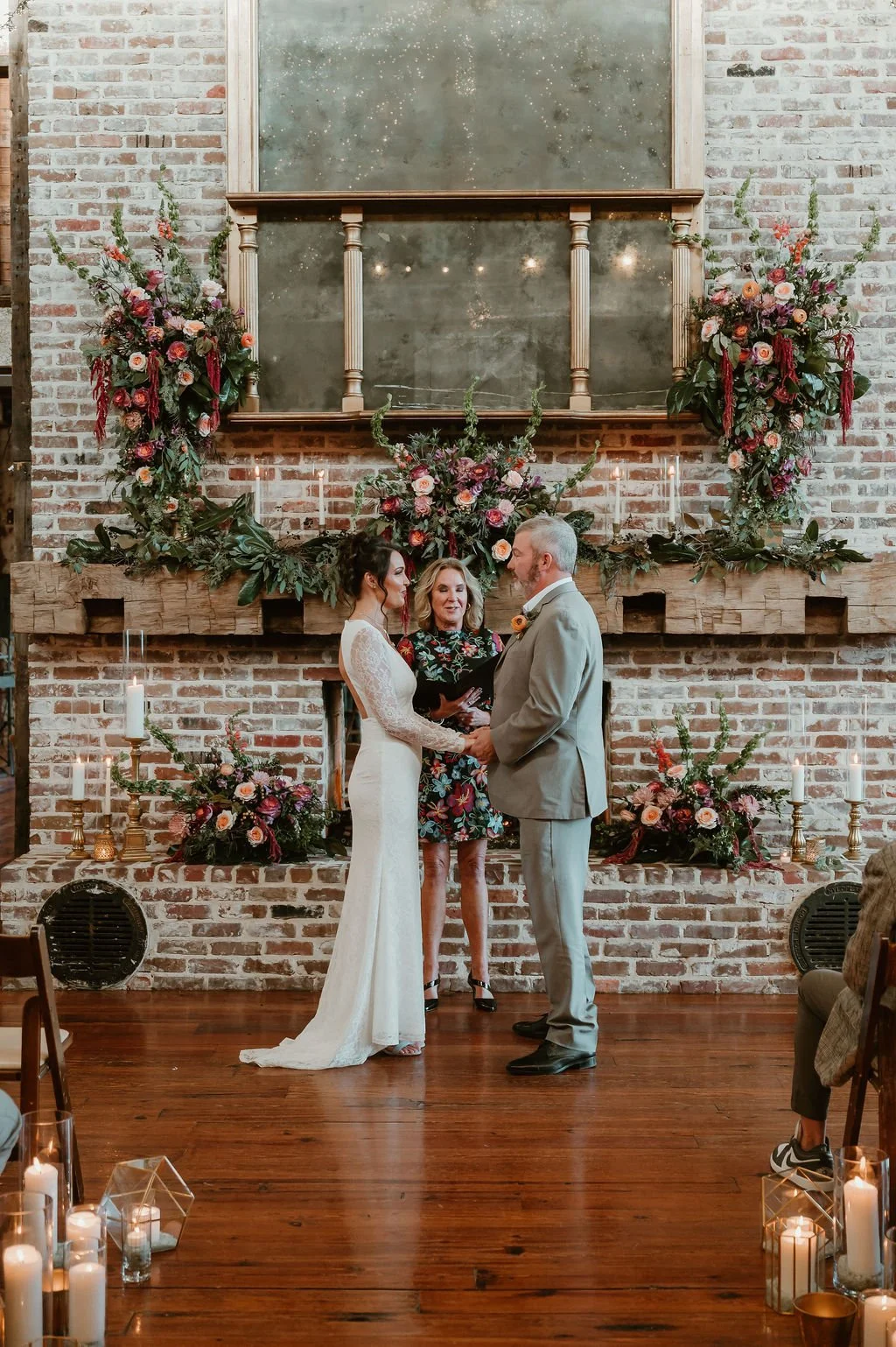 couple getting married in front of fireplace with gorgeous floral in faulkner room at The Jefferson Oxford