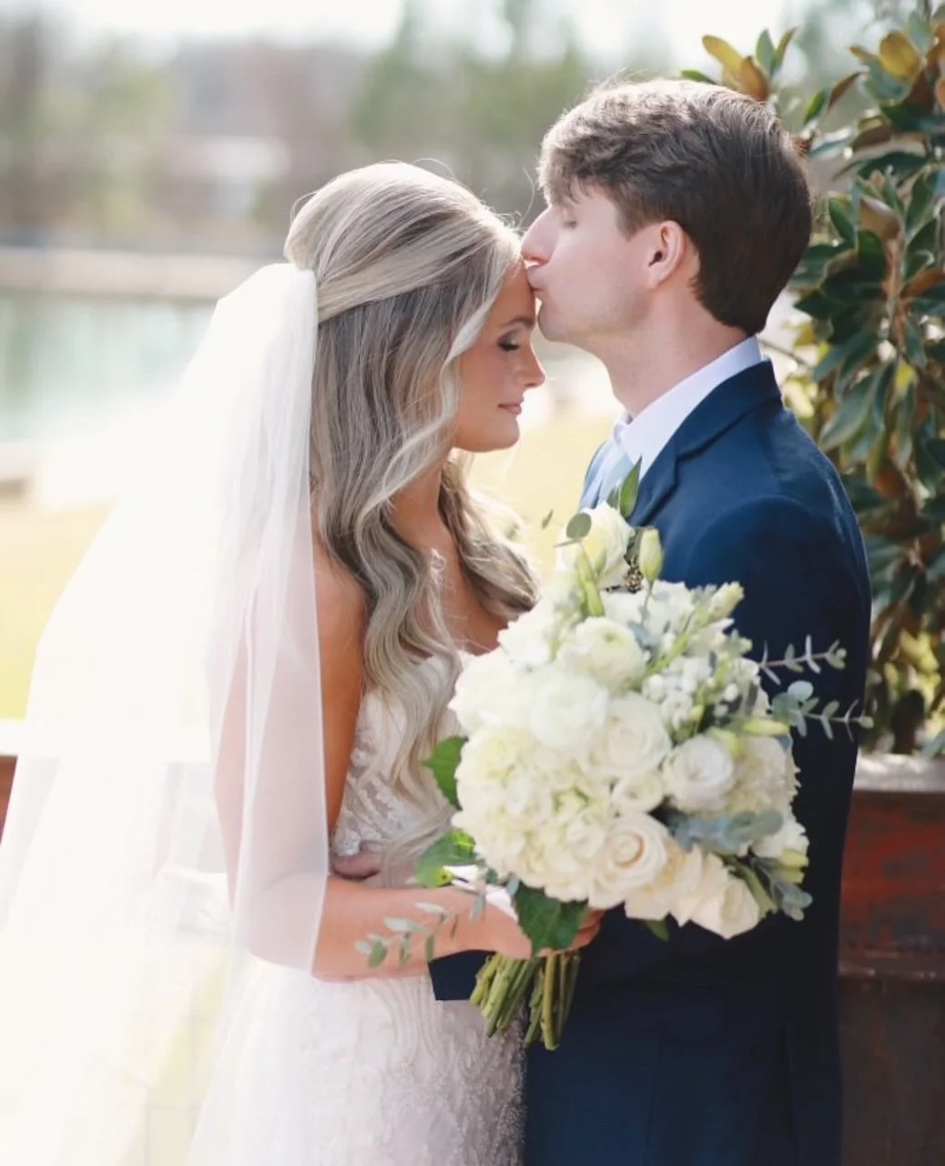 couple kissing on lakefront stairway wedding day at the jefferson oxford ms