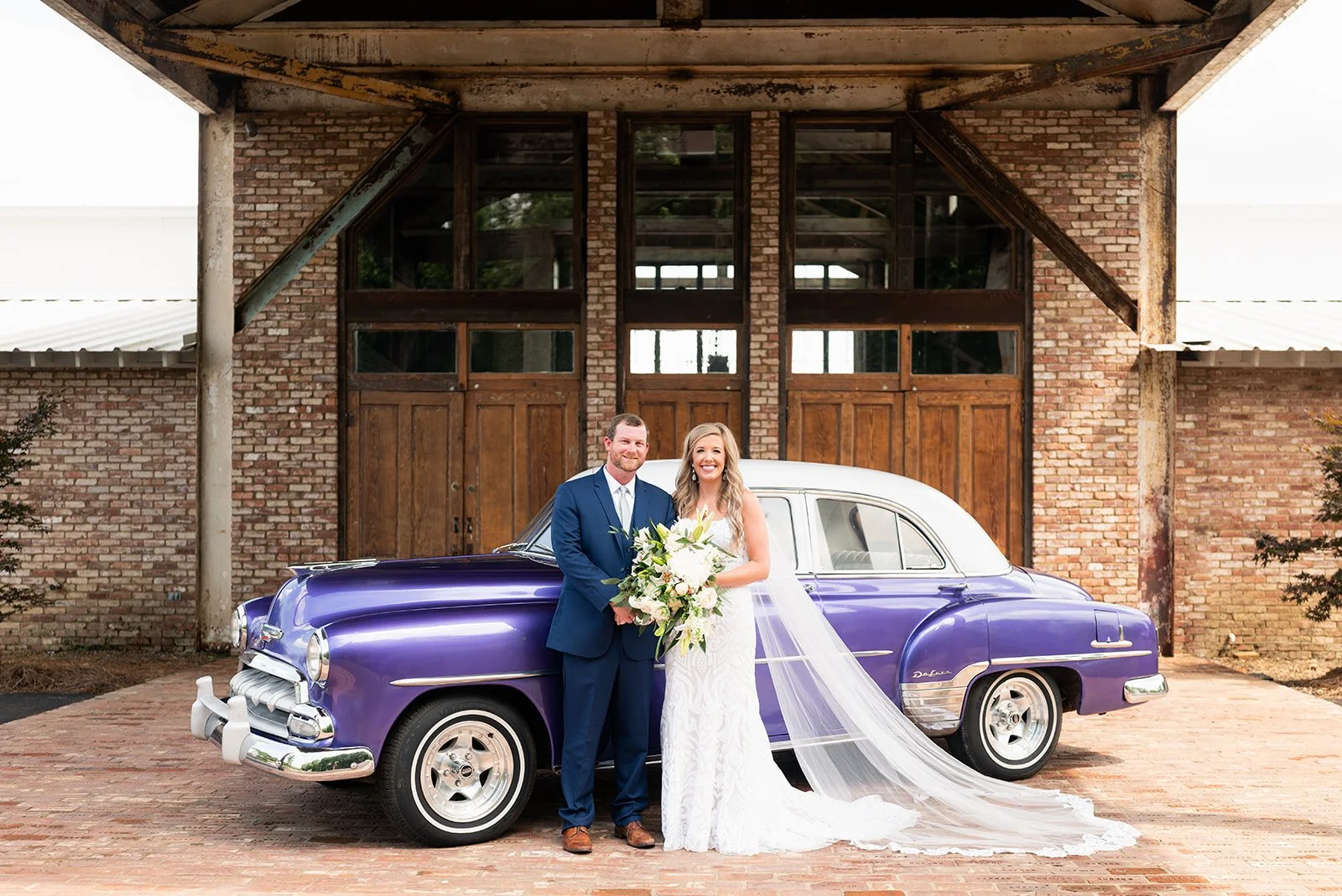 couple with purple getaway car at the entrance of the jefferson oxford ms