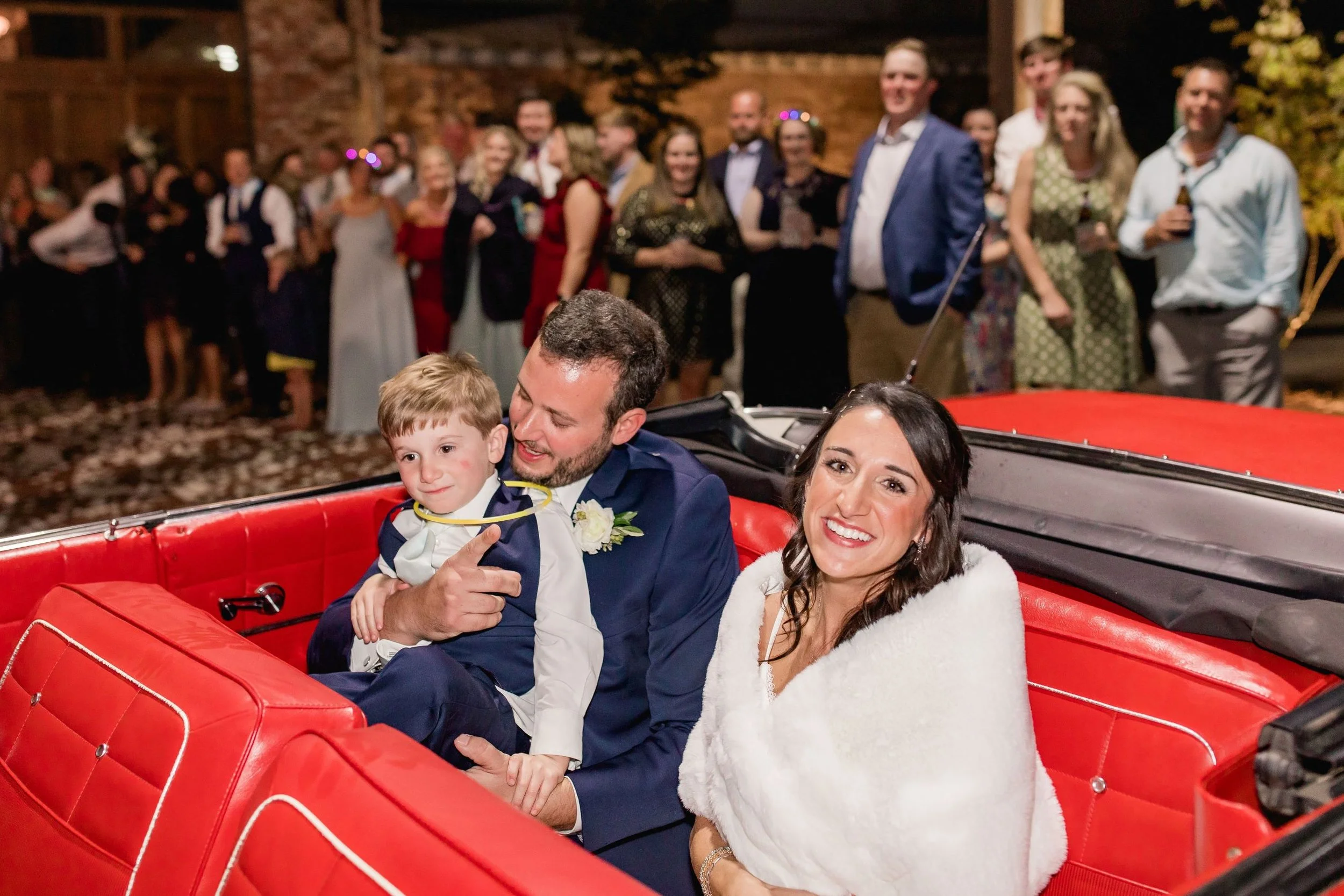 bride and groom in a red convertible for send-off from wedding reception at the Jefferson Oxford