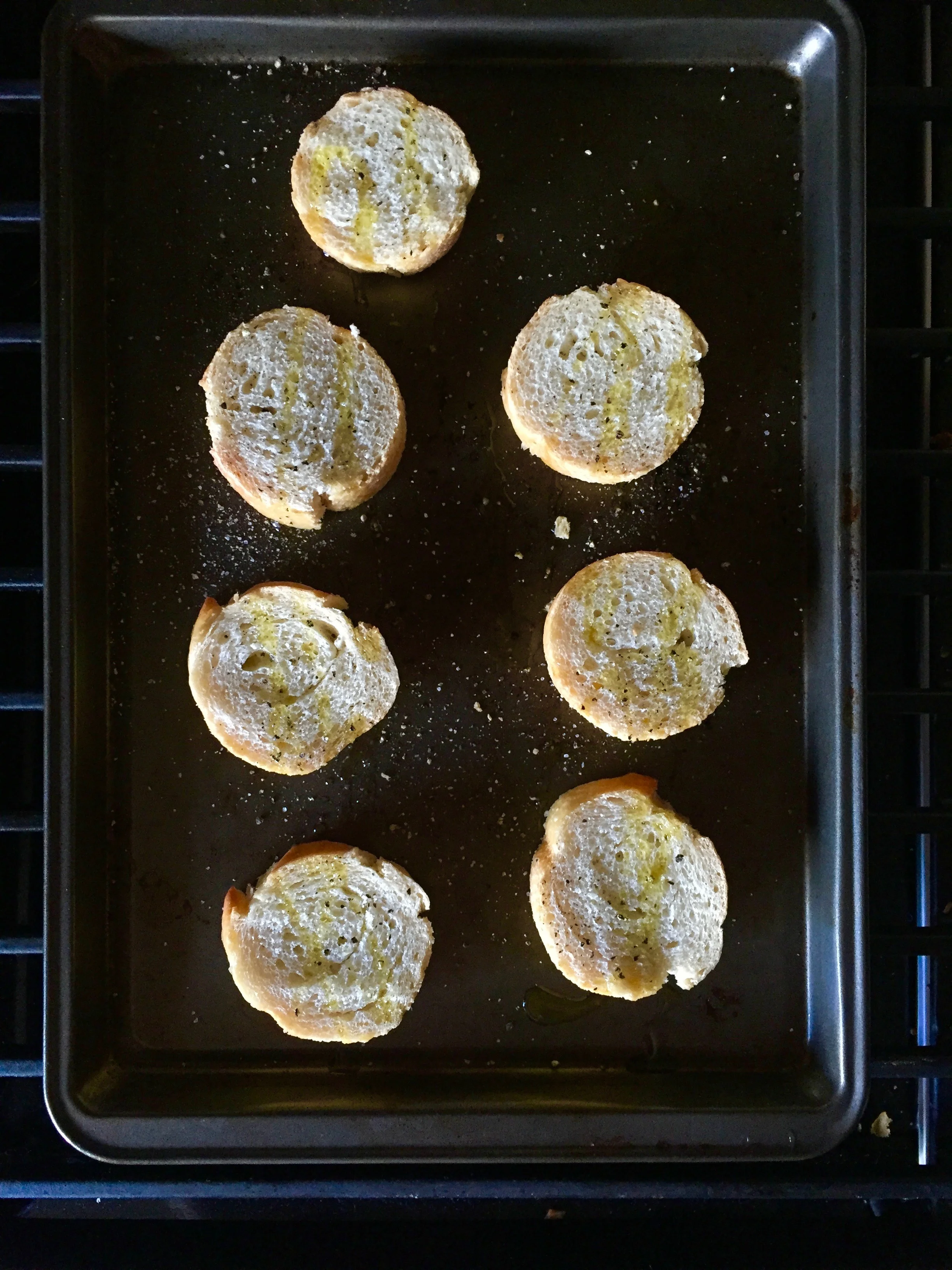 Toss the crostini into the oven, with a drizzle of olive oil, salt and pepper.