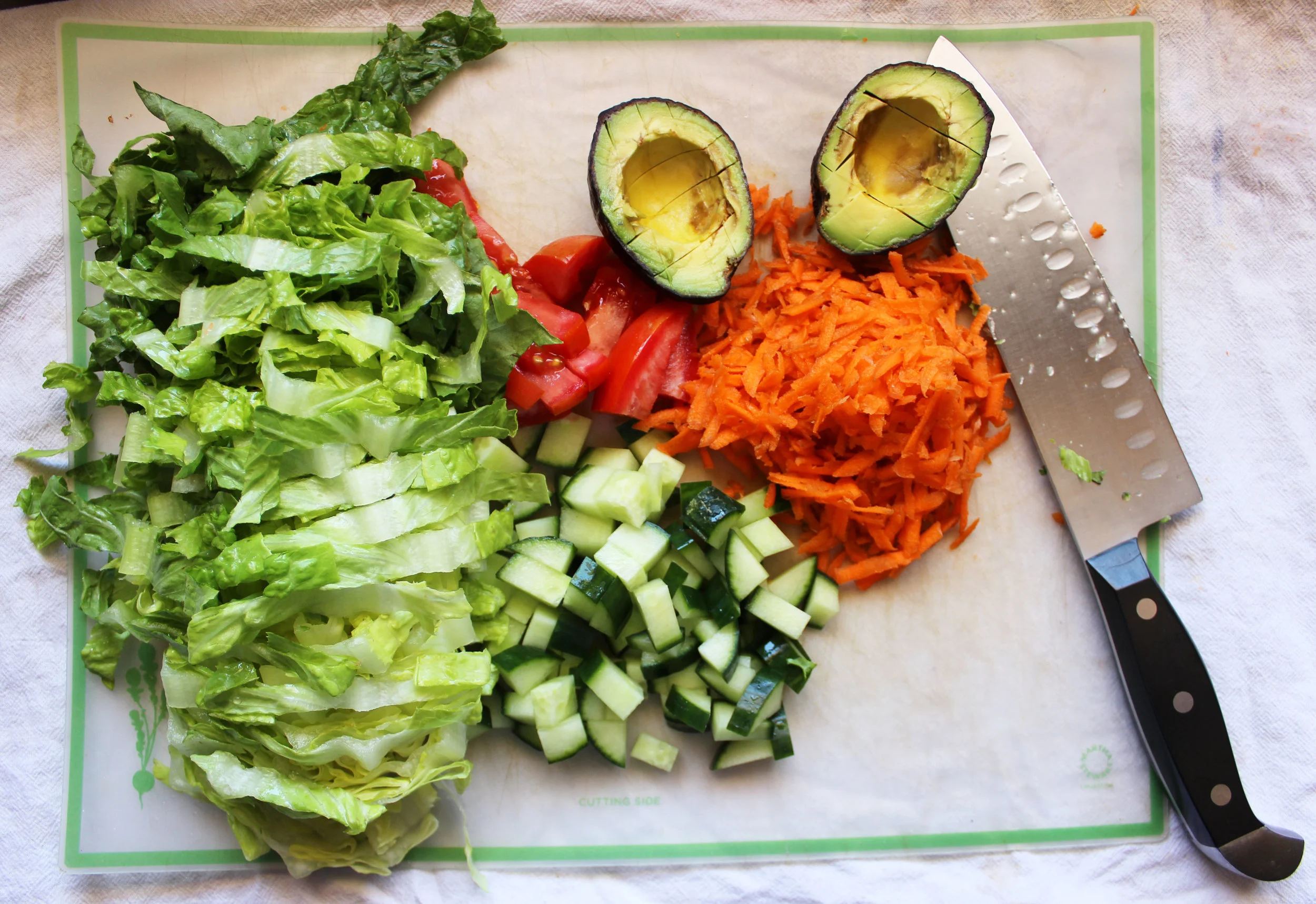 Chop romaine, cuke, tomato. Cut avo in it's skin, easier to get out that way! I like shredded carrot.