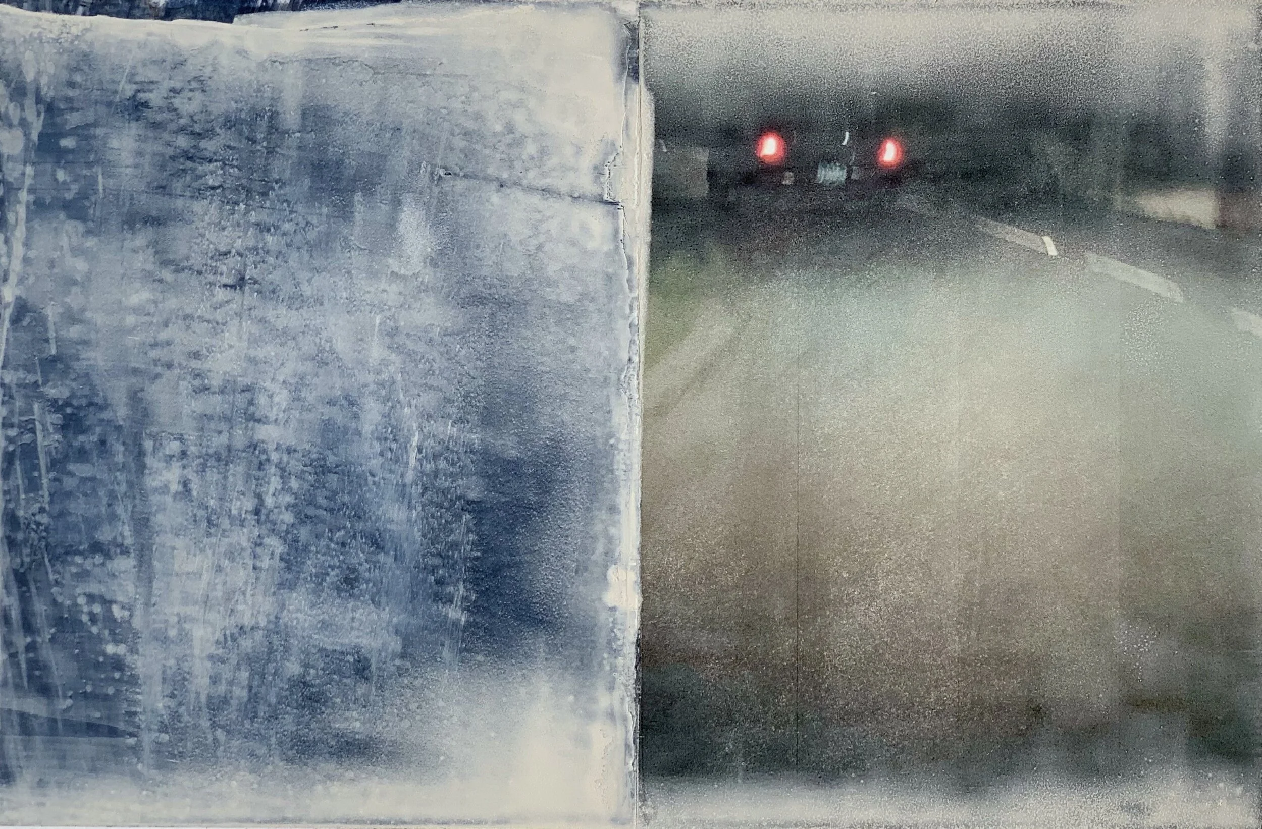 The image shows a side mirror of a vehicle on the left with a foggy or icy surface, while the view through the mirror shows a dark road with vehicle taillights in the distance.