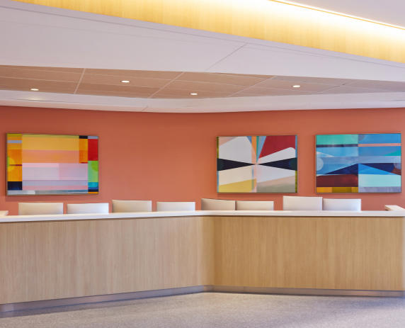 3 large colorful paintings behind a hospital  registration desk