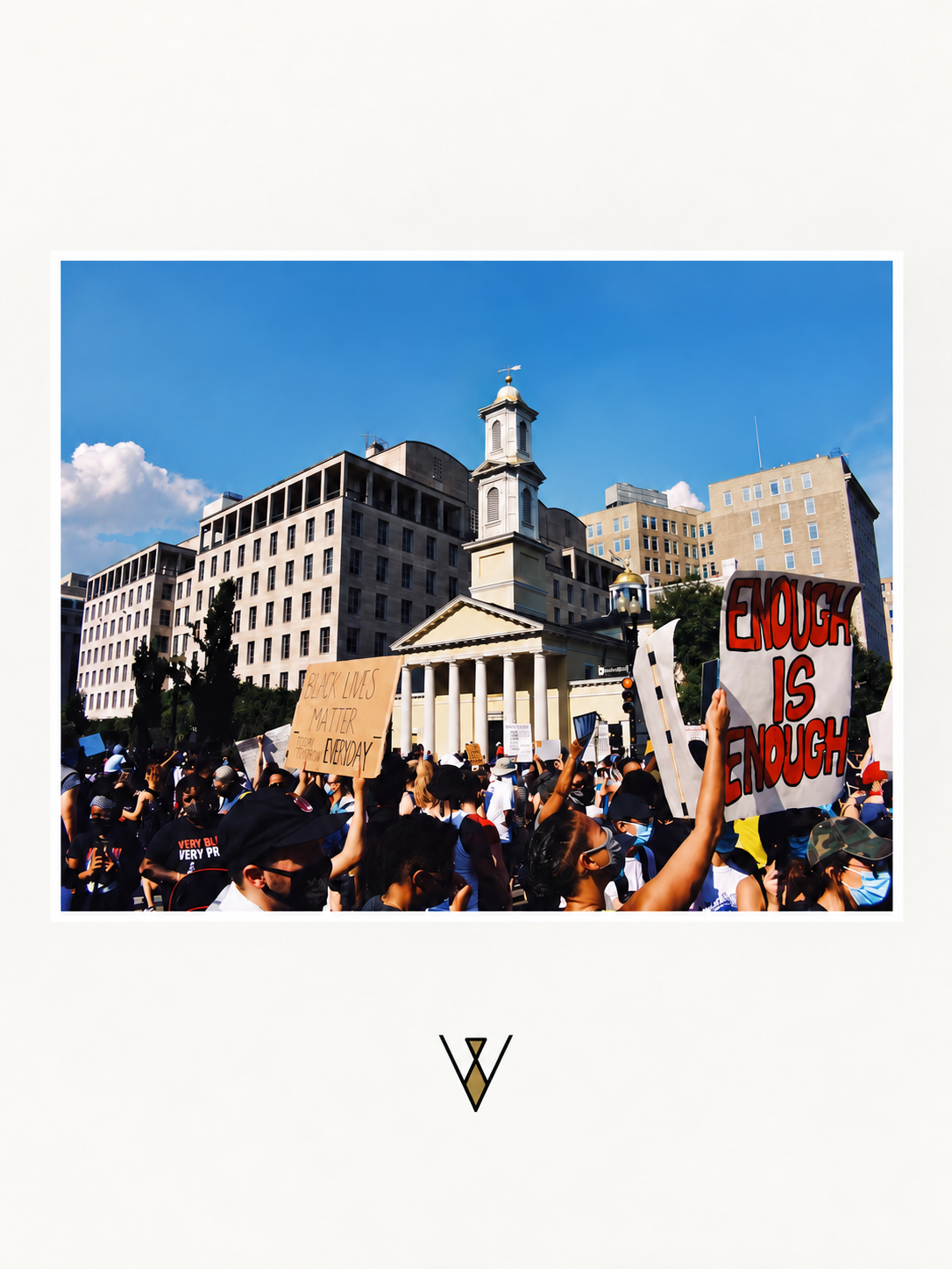 Crowd of protesters holding signs, including a sign that reads 'Enough is Enough', in front of a historic building with columns and a neighboring tall building, under a bright blue sky.
