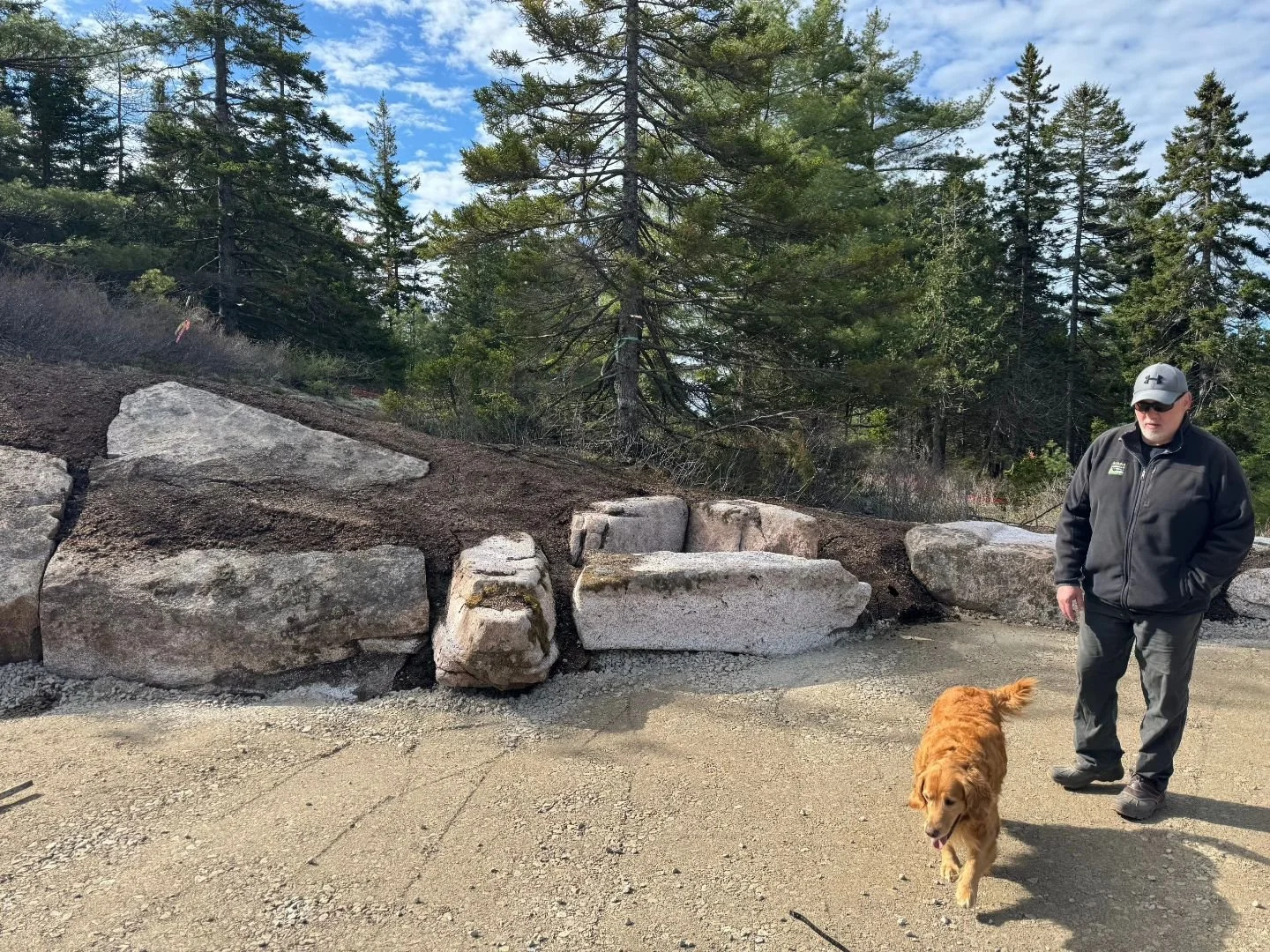 Spring is off to a good start. On this project, we harvested large weathered granite ledge pieces last Fall before they blasted for the foundation. Now, we are placing these large pieces back to retain the cut slope in what we call "faux ledge.&