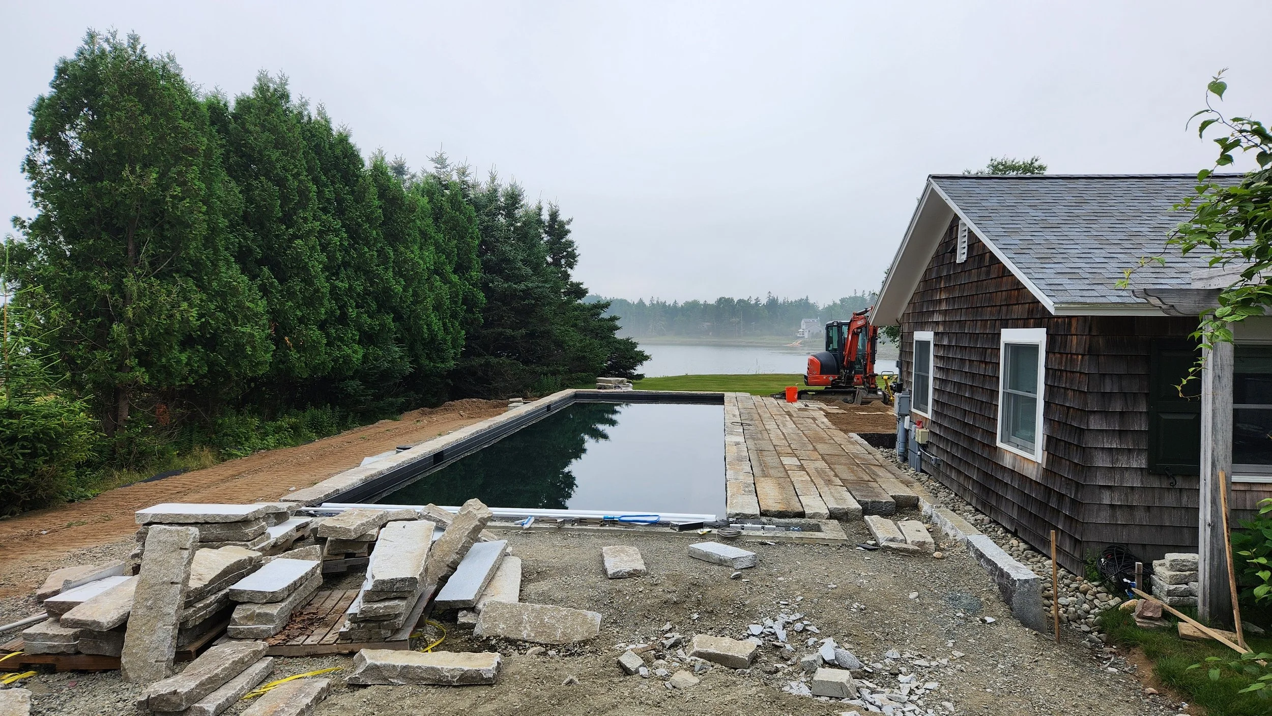 Starting on the pool paving with reclaimed granite curbing
